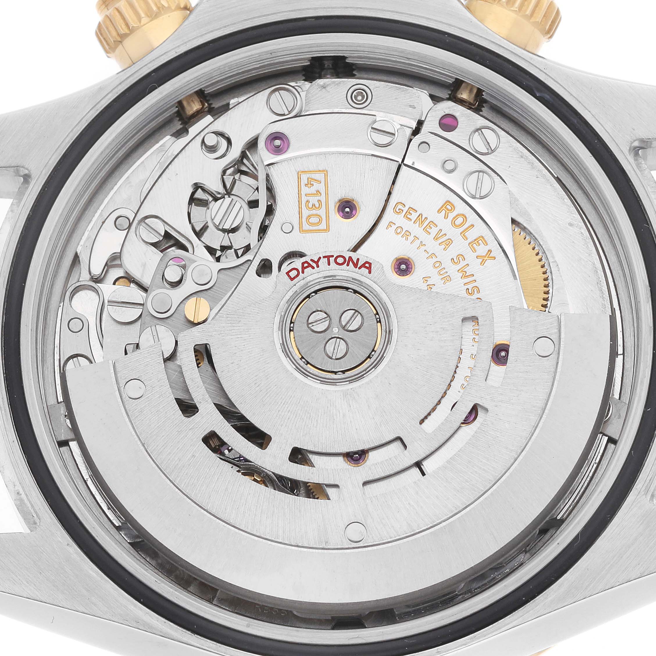The image shows the movement of a Rolex Daytona 116523 Men's Steel and Gold (two tone) White Dial watch viewed from the back, featuring gears and engravings.