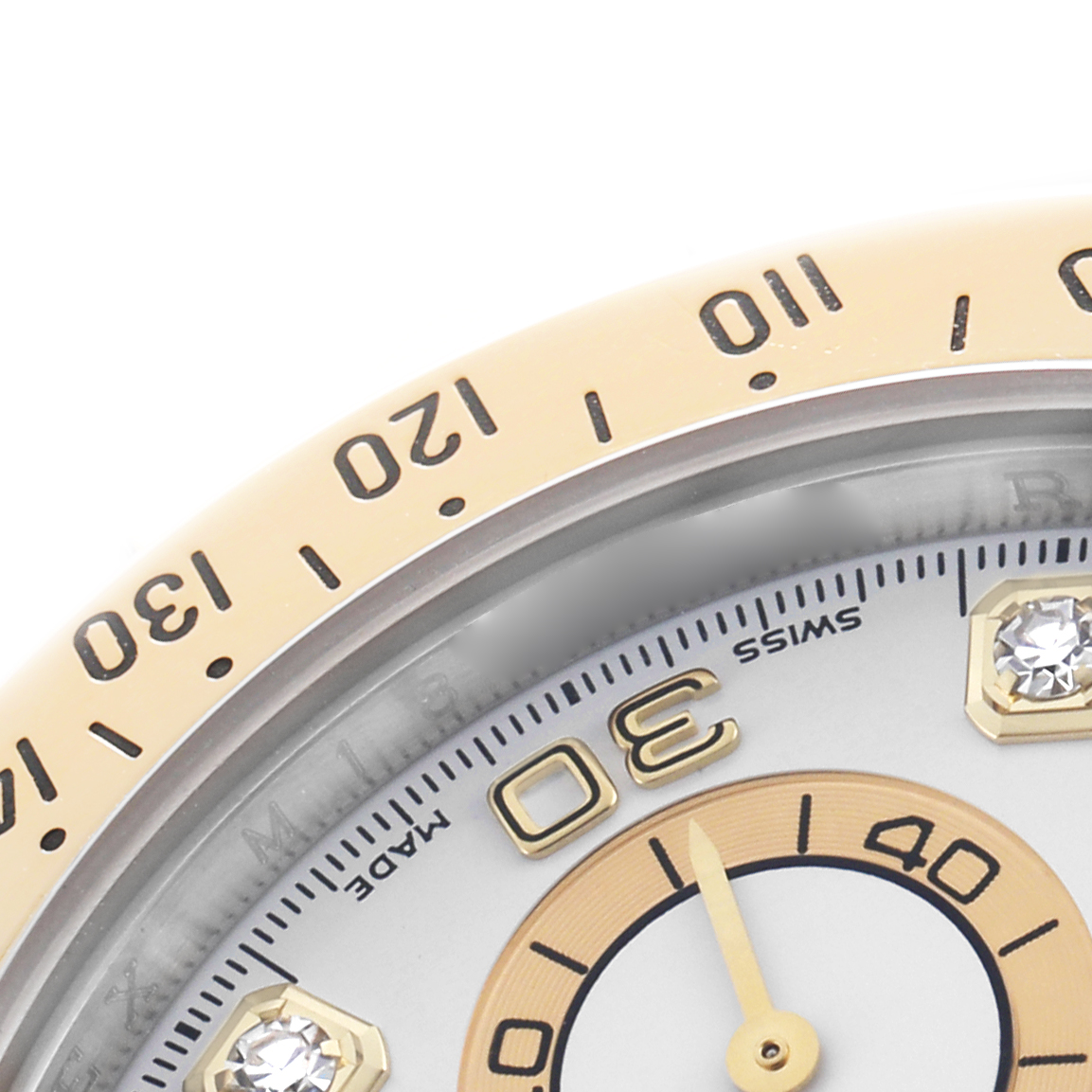 The image shows a close-up of a Rolex Daytona 116523 Men's Steel and Gold (two tone) White Dial watch, focusing on the bezel and part of the dial with a visible marker.