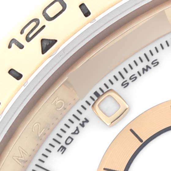The image shows a close-up of the bezel and part of the dial of a Rolex Daytona 116518 Men's Yellow Gold White Dial 116518 Men's Yellow Gold White Dial watch.