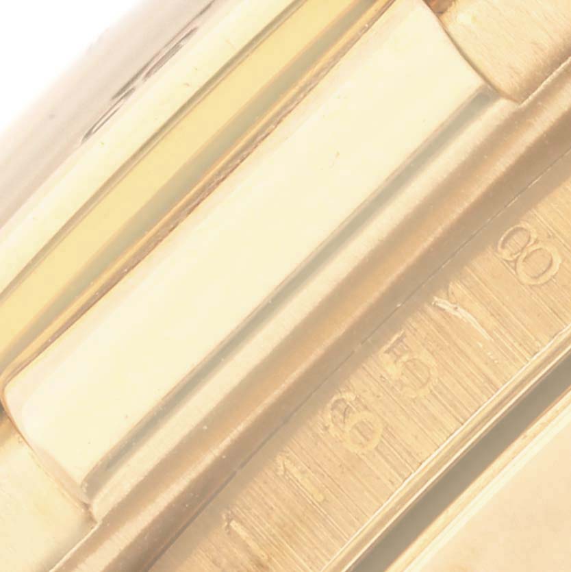 The image shows a close-up of the bezel and engraved tachymetric scale on the Rolex Daytona 116518 Men's Yellow Gold White Dial 116518 Men's Yellow Gold White Dial.