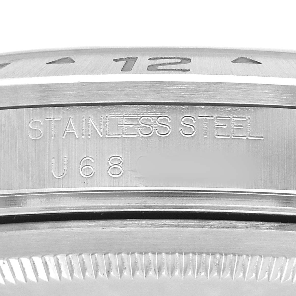 The image shows a close-up of the side of the Rolex Explorer 16570 Men's Stainless Steel White Dial watch case, highlighting the stainless steel material and engravings.