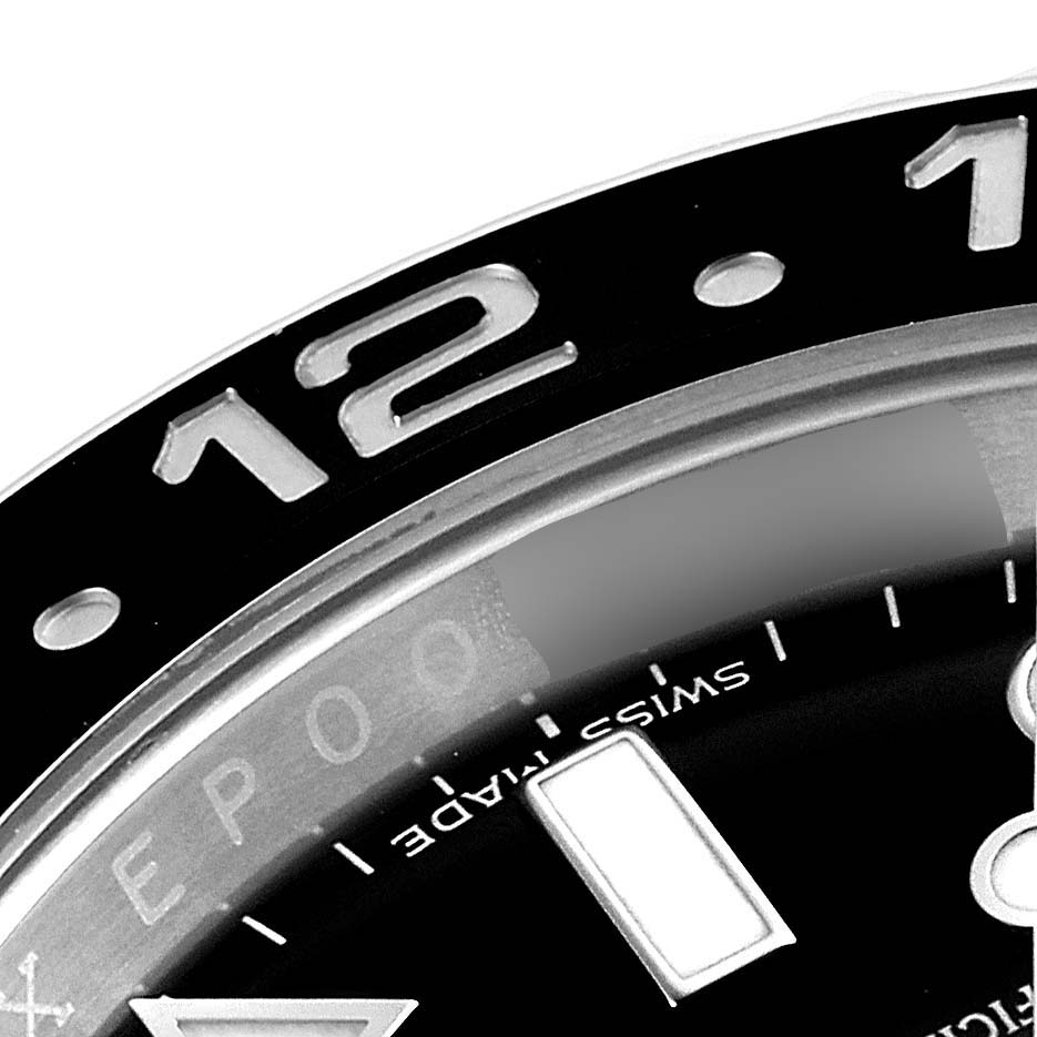 The image shows a close-up of the top portion of the bezel and dial of a Rolex GMT-Master 116710 Men
s Stainless Steel Black Dial 116710 Men
s Stainless Steel Black Dial, highlighting the 12 o
clock marker.
