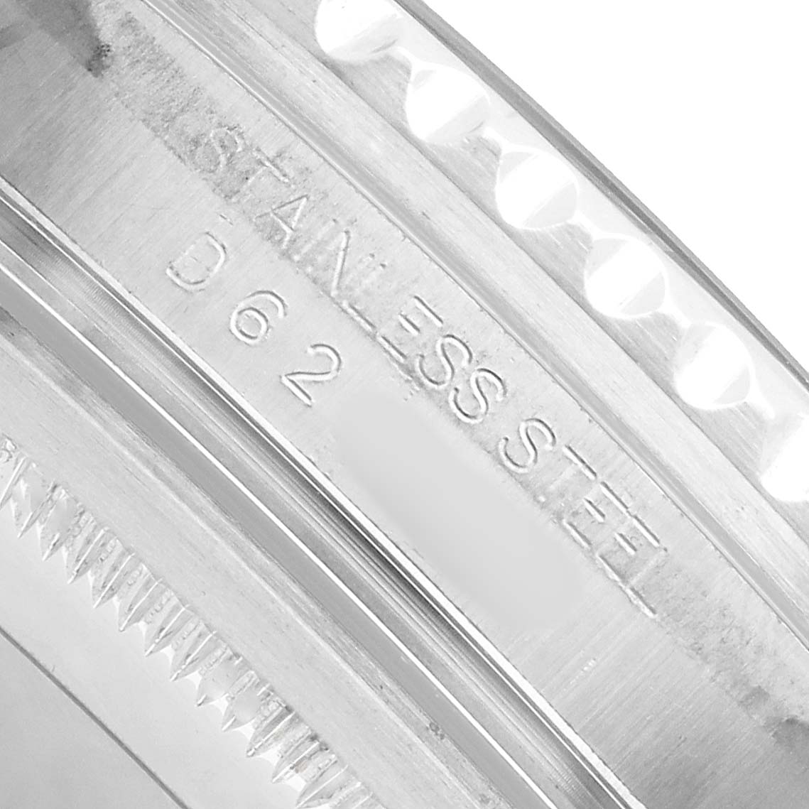 The image shows a close-up of the lettering on the stainless steel part of a Rolex GMT-Master 16710 Men's Stainless Steel Black Dial watch, likely the inner bezel or case edge.