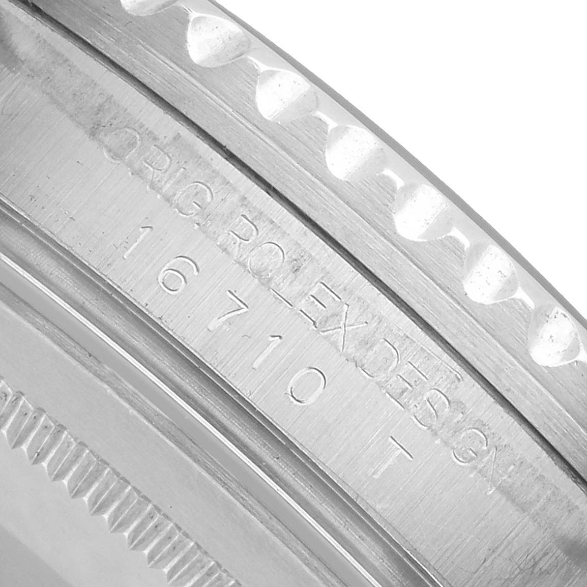 The image shows an angled close-up of the side edge of the Rolex GMT-Master 16710 Men's Stainless Steel Black Dial bezel, displaying the model number and design engraving.