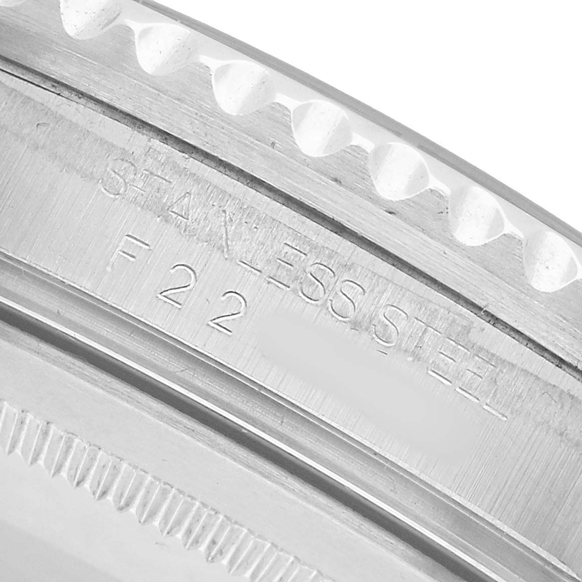 The image shows a close-up of the side of a Rolex GMT-Master 16710 Men's Stainless Steel Black Dial watch, highlighting the stainless steel engraving on the case.