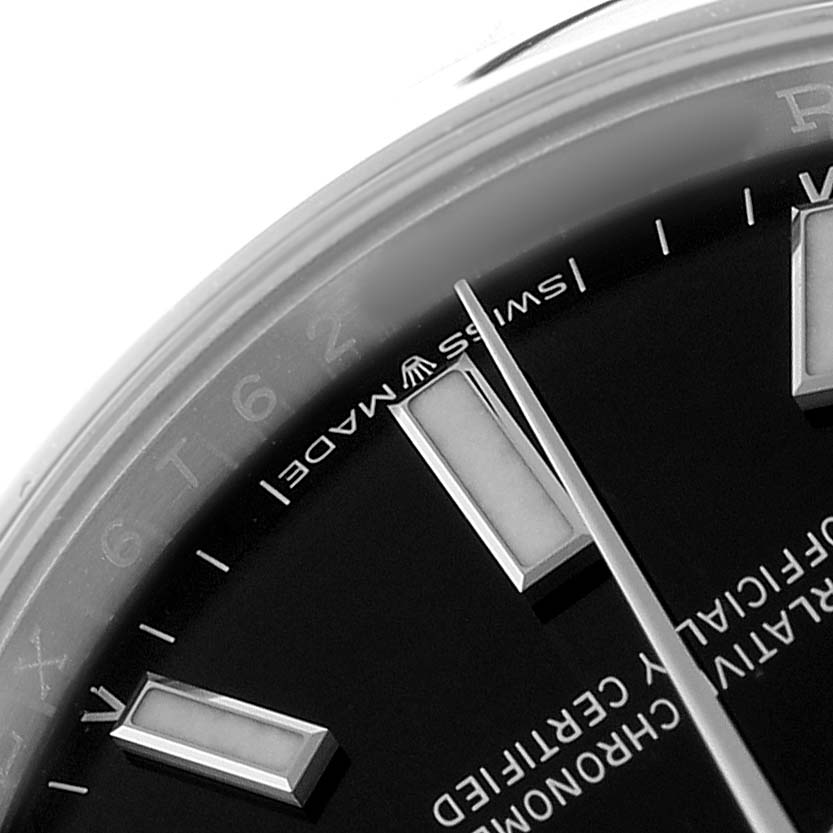 The image shows a close-up of the dial and hands of a Rolex Oyster Perpetual 124200 Men's Stainless Steel Black Dial watch from an angled perspective.