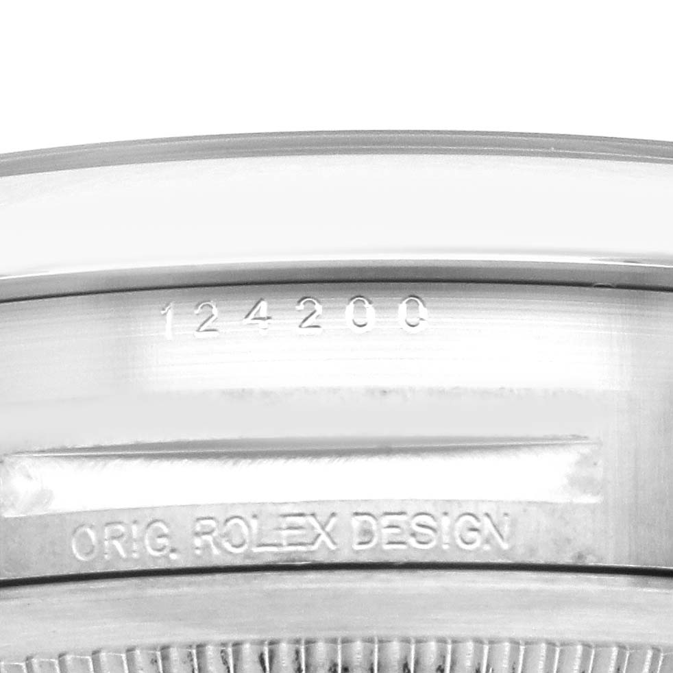 The image shows the side of a Rolex Oyster Perpetual 124200 Men's Stainless Steel Black Dial case, highlighting the model number and "ORIG. ROLEX DESIGN" engraving.