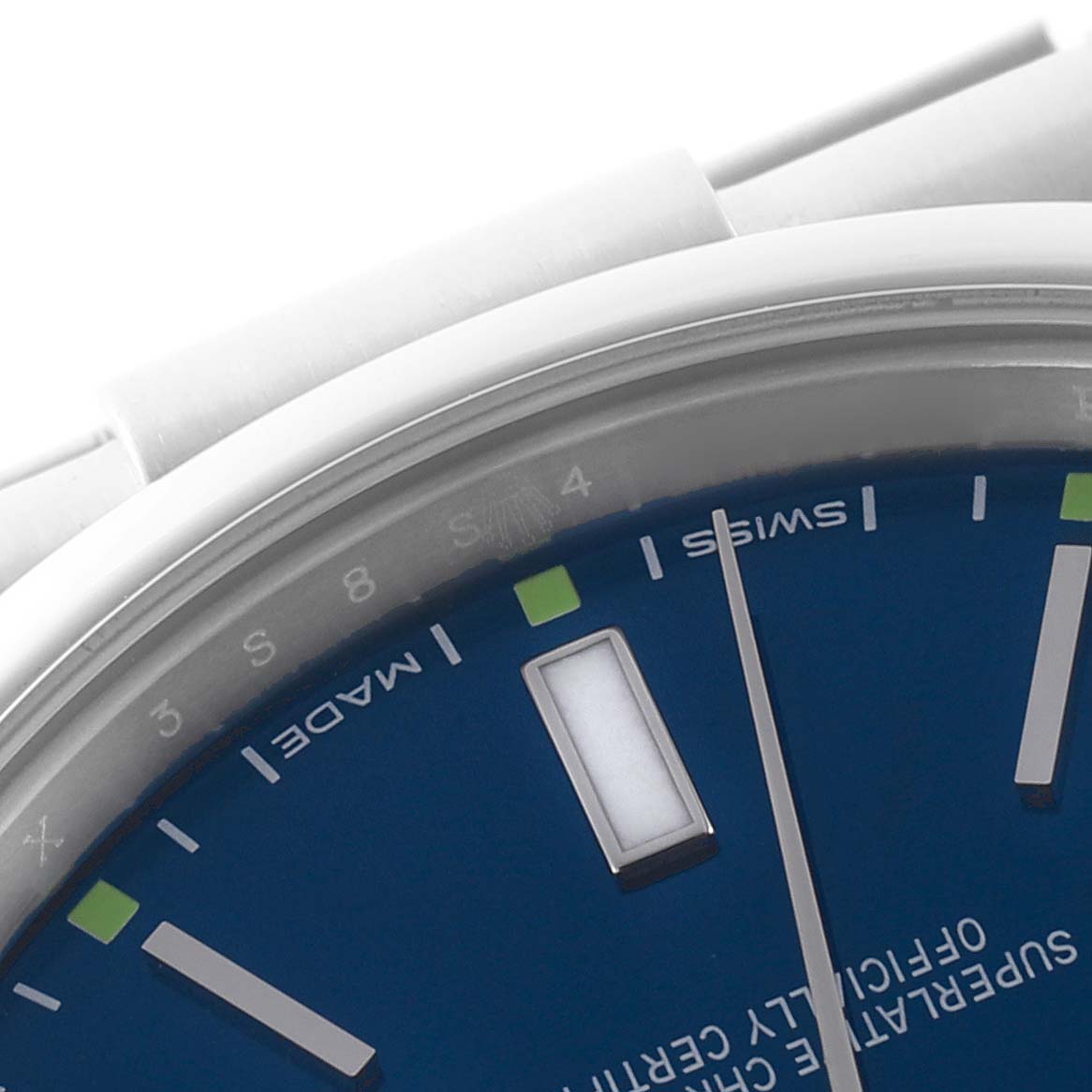 The image shows a close-up of the blue dial and silver hour markers of the Rolex Oyster Perpetual 114300 Men's Stainless Steel Blue Dial 114300 Men's Stainless Steel Blue Dial watch.