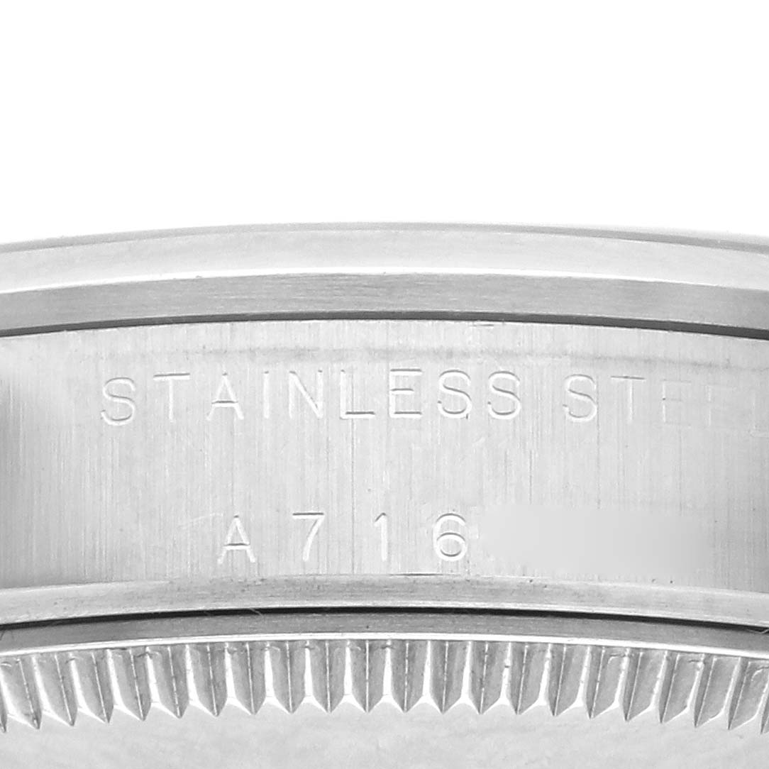 The image shows the side of a Rolex Mid-Size 77080 Women's Stainless Steel Pink Dial 77080 Women's Stainless Steel Pink Dial watch, highlighting the engraved serial number and stainless steel label.