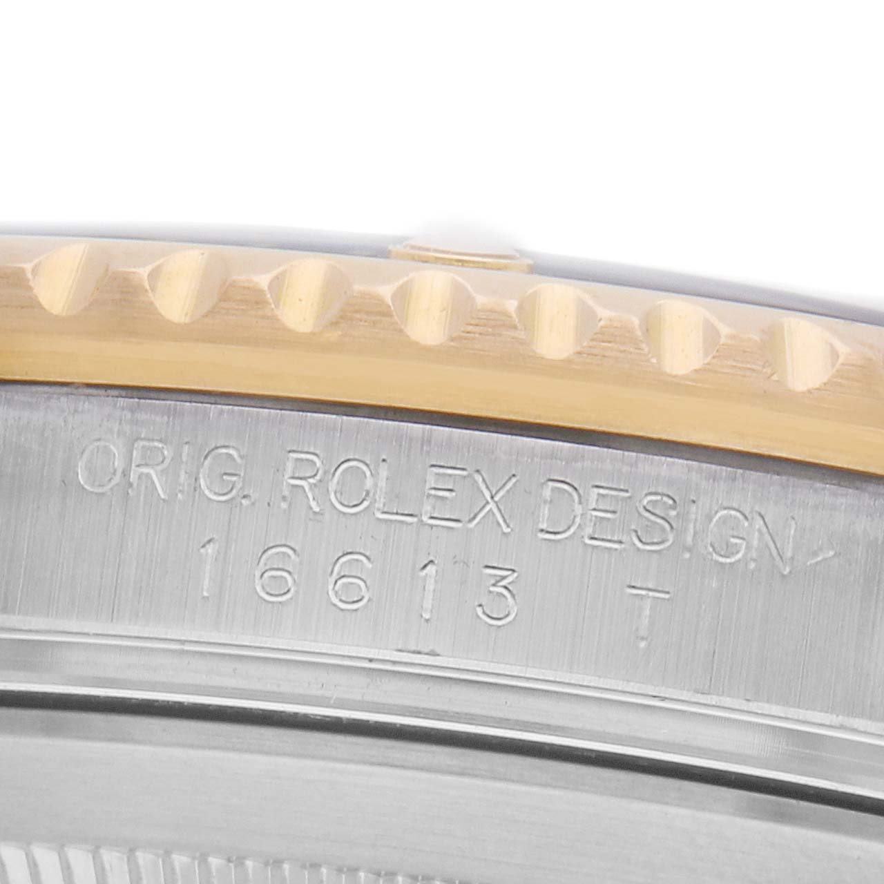 The image shows a close-up of the Rolex Submariner 16613 Men's Steel and Gold (two tone) Black Dial's bezel and engraved reference number on the watch case's side.