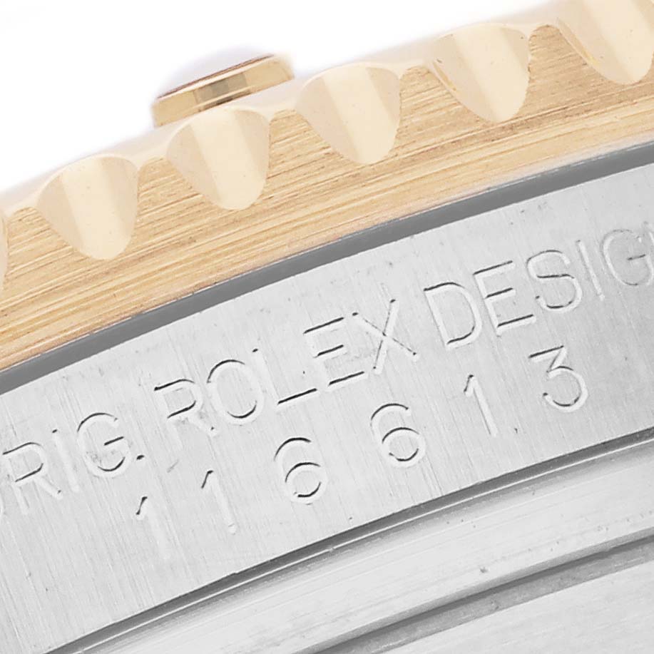 The image shows a close-up of the Rolex Submariner 116613LB Men's Steel and Gold (two tone) Blue Dial 116613LB Men's Steel and Gold (two tone) Blue Dial watch case edge with serial number engraving.
