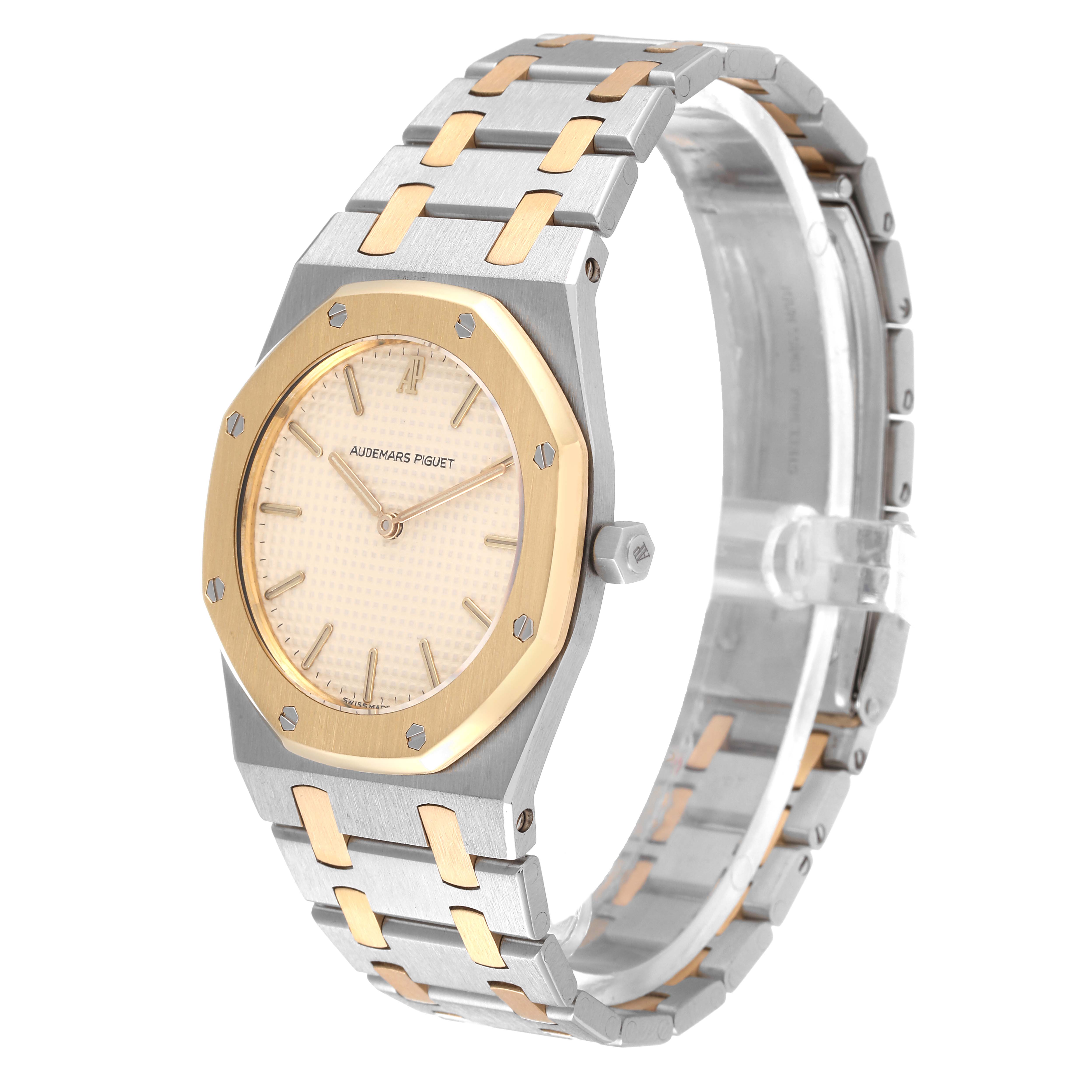 The image shows a side angle of the Audemars Piguet Royal Oak 56303SA Men's Steel and Gold (two tone) Beige Dial 56303SA Men's Steel and Gold (two tone) Beige Dial watch, featuring its bezel, dial, hands, crown, and bracelet.