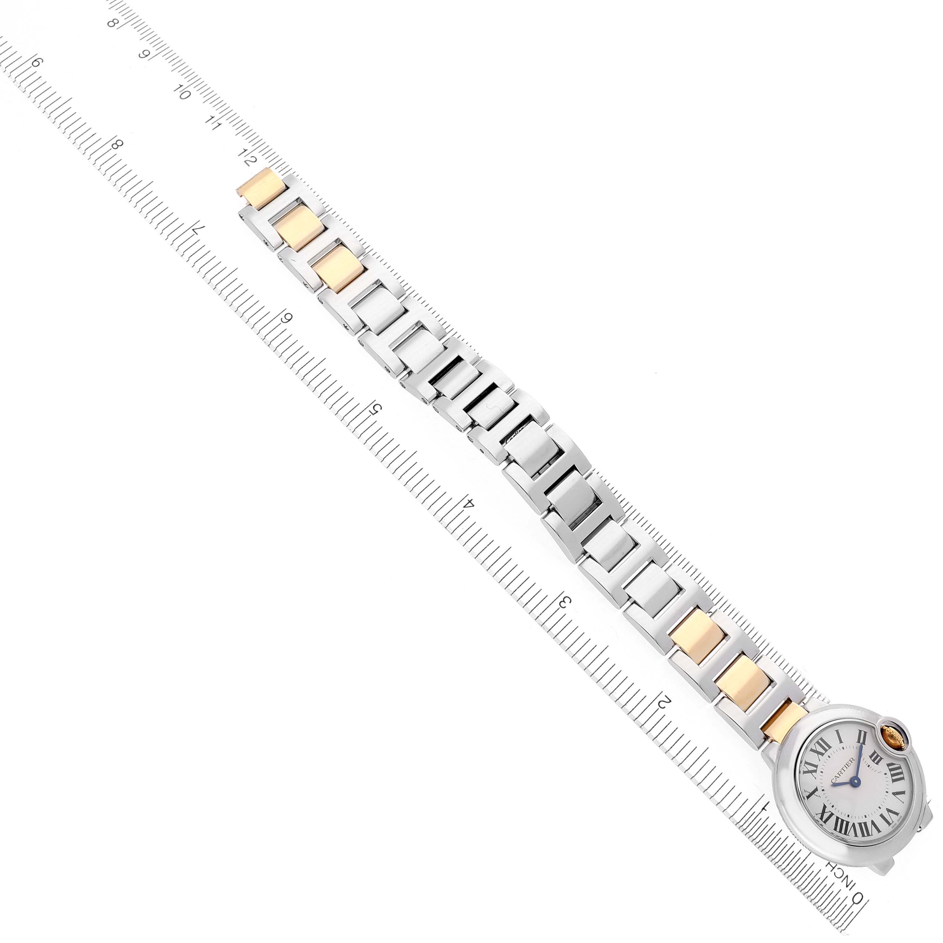 The Cartier Ballon Bleu W69007Z3 Women
s Steel and Gold (two tone) Silver Dial W69007Z3 Women
s Steel and Gold (two tone) Silver Dial watch is shown from above, featuring its face and two-tone bracelet placed along a ruler.