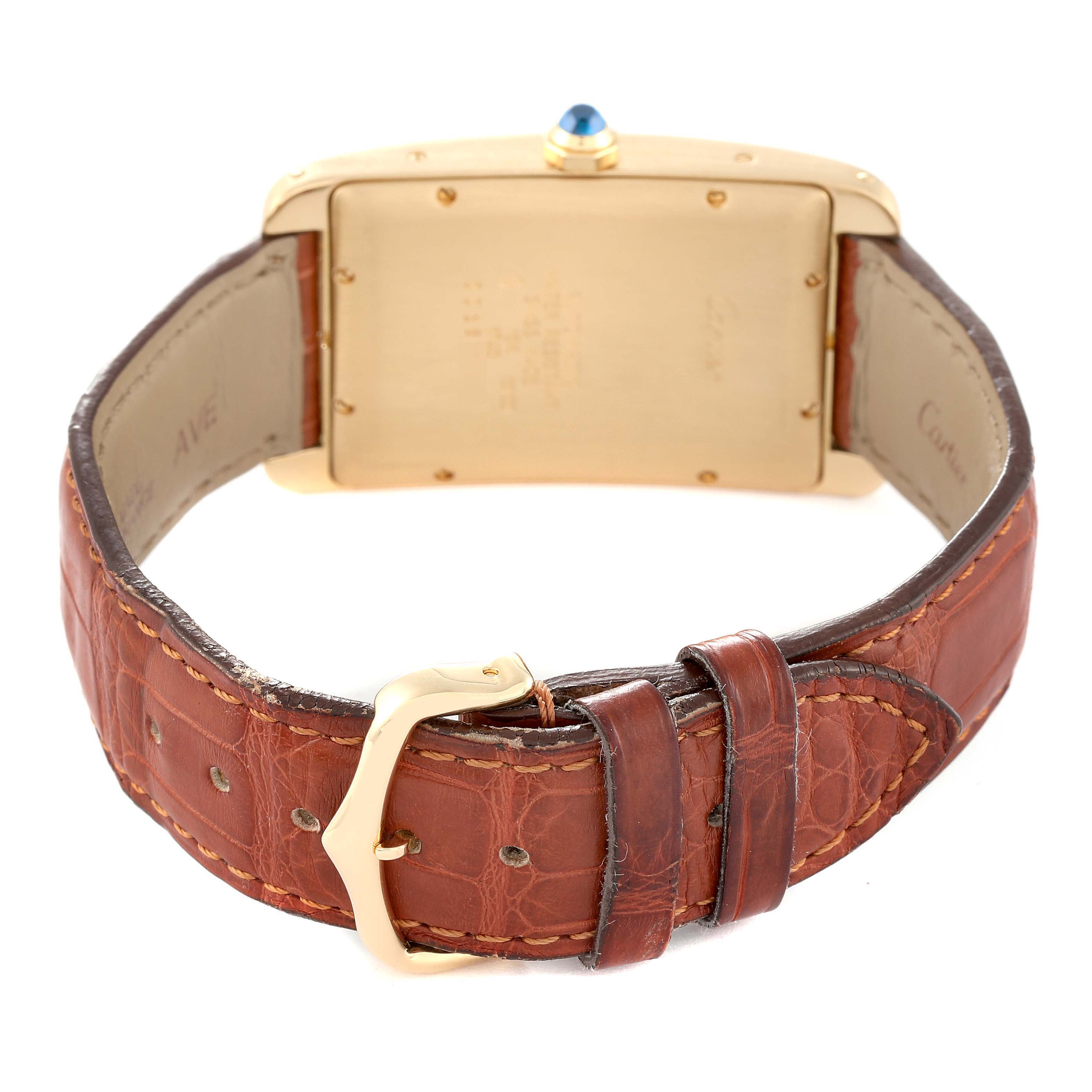 The image shows the back view of a Cartier Tank Americaine W2603156 Men's Yellow Gold Silver Dial W2603156 Men's Yellow Gold Silver Dial watch with a brown leather strap and gold buckle.