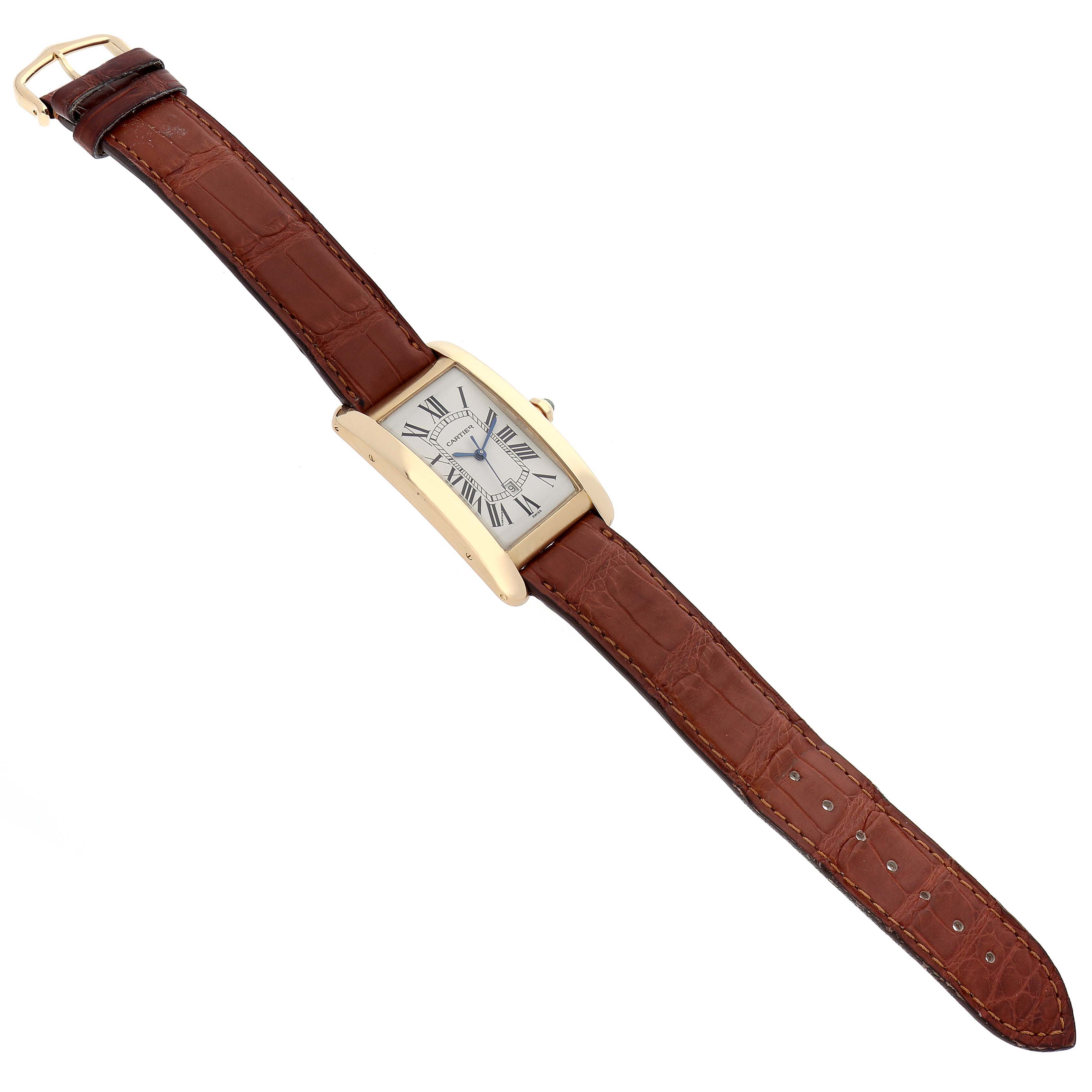 The Tank Americaine model by Cartier is shown at a top-down angle featuring the full watch and brown leather strap.