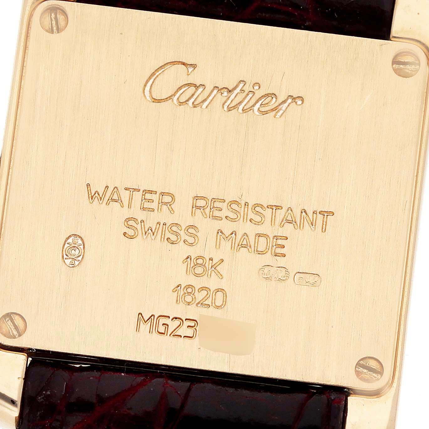 The image shows the back of a Cartier Tank Française watch, highlighting engravings and part of the leather strap.