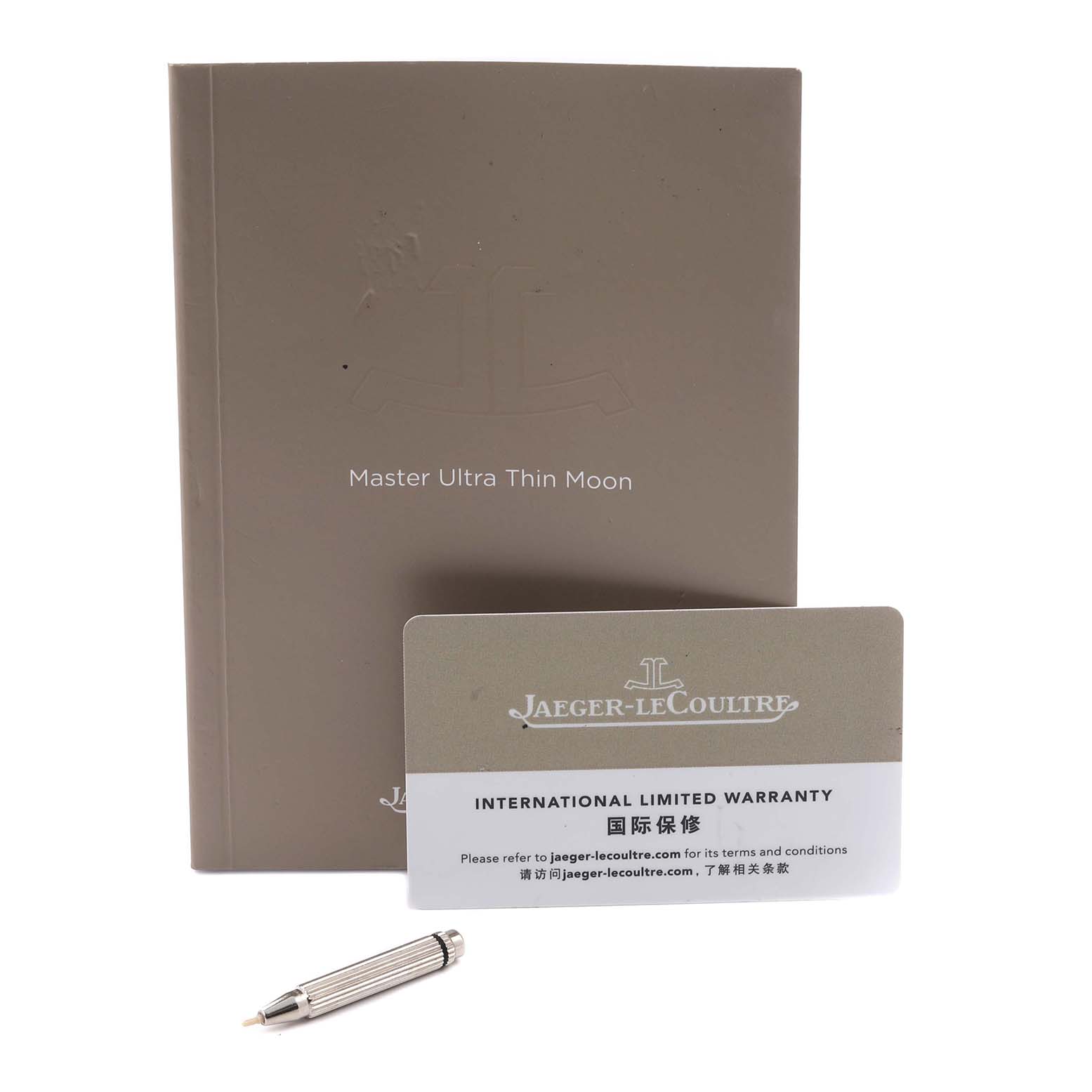 The image shows a manual, warranty card, and tool for the Jaeger-LeCoultre Master Ultra Thin Moon.