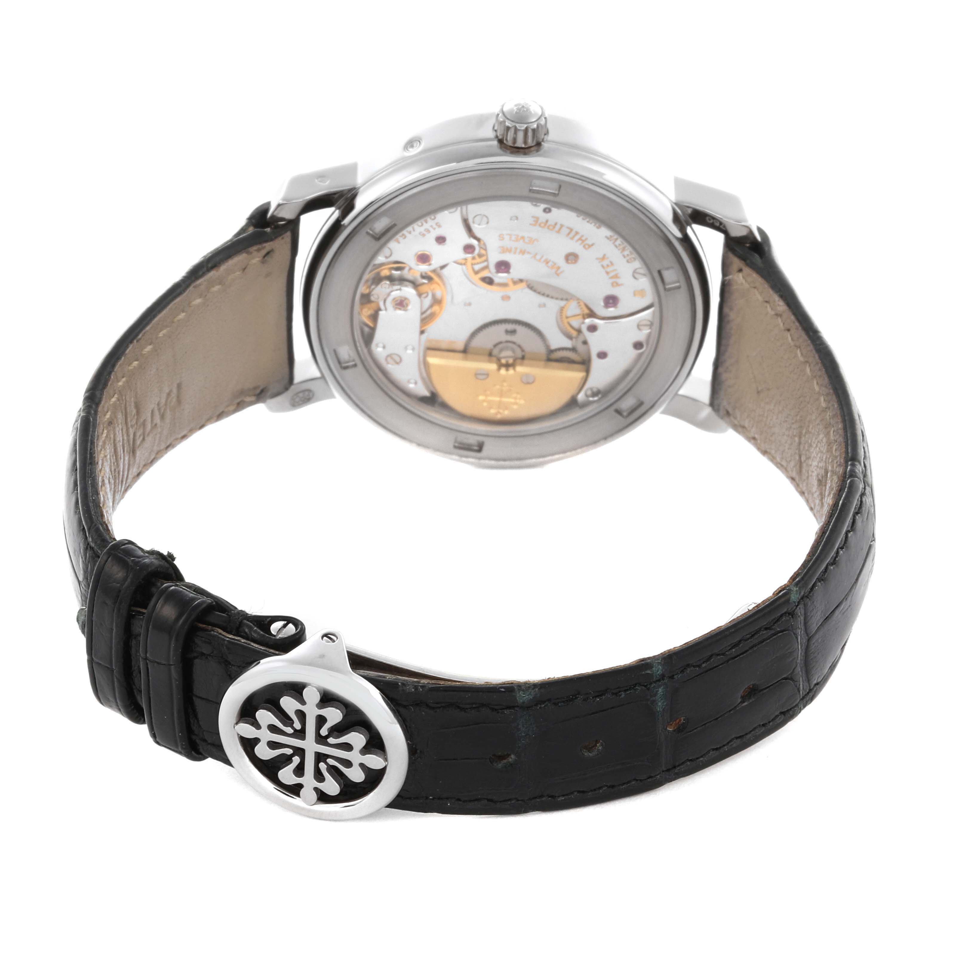 The Patek Philippe Complications 5055G-001 Men's White Gold Black Dial 5055G-001 Men's White Gold Black Dial watch is shown from the back, displaying the intricate movement and leather strap.