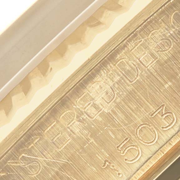 The image shows a close-up of the fluted bezel and edge engraving on a Rolex Date watch.