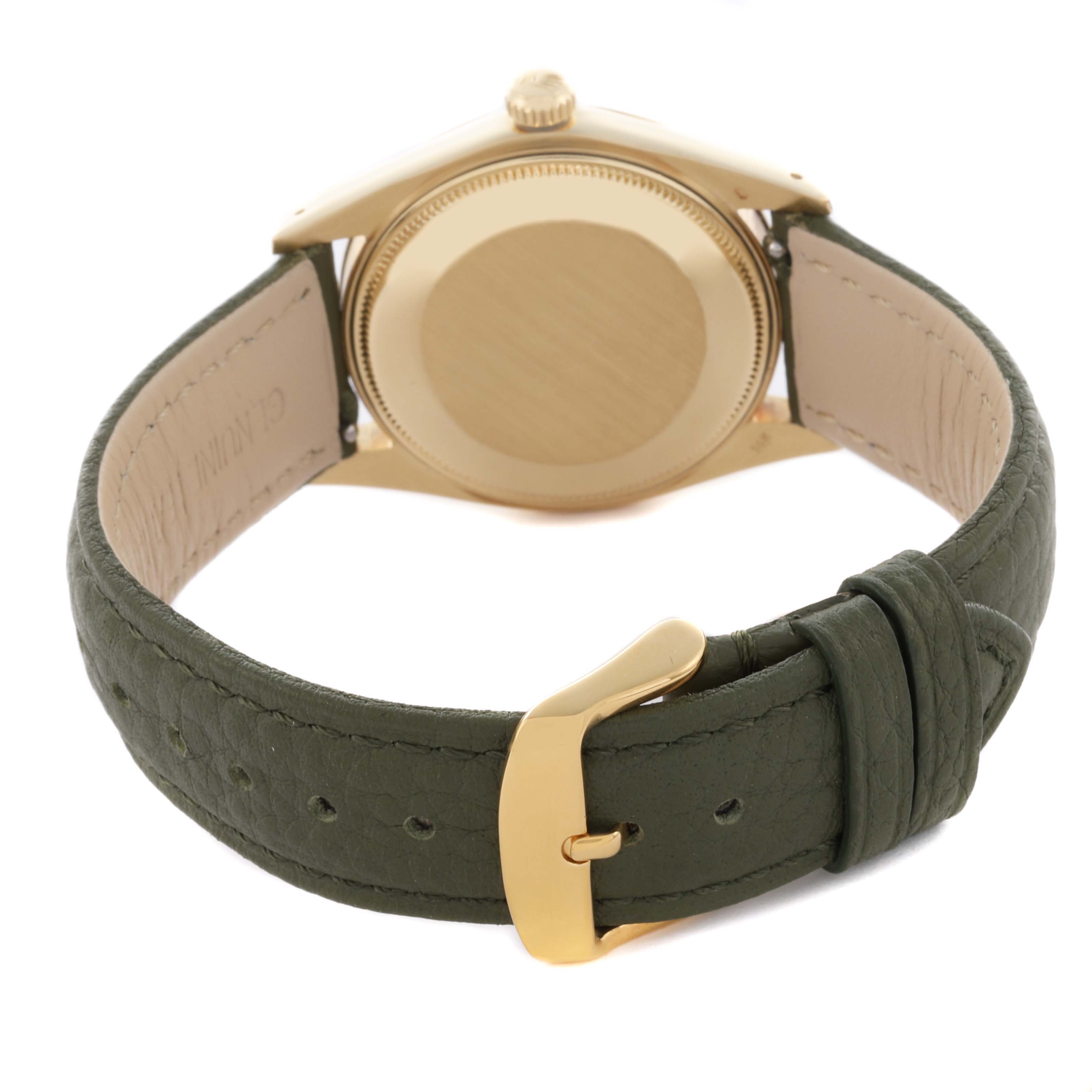 The image shows the back casing and green leather strap of a Rolex Date watch, highlighting the buckle.