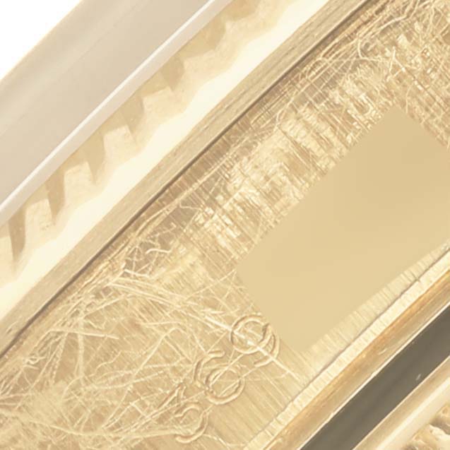 This image shows a close-up of the engraved side details and fluted bezel of a Rolex Date model watch.