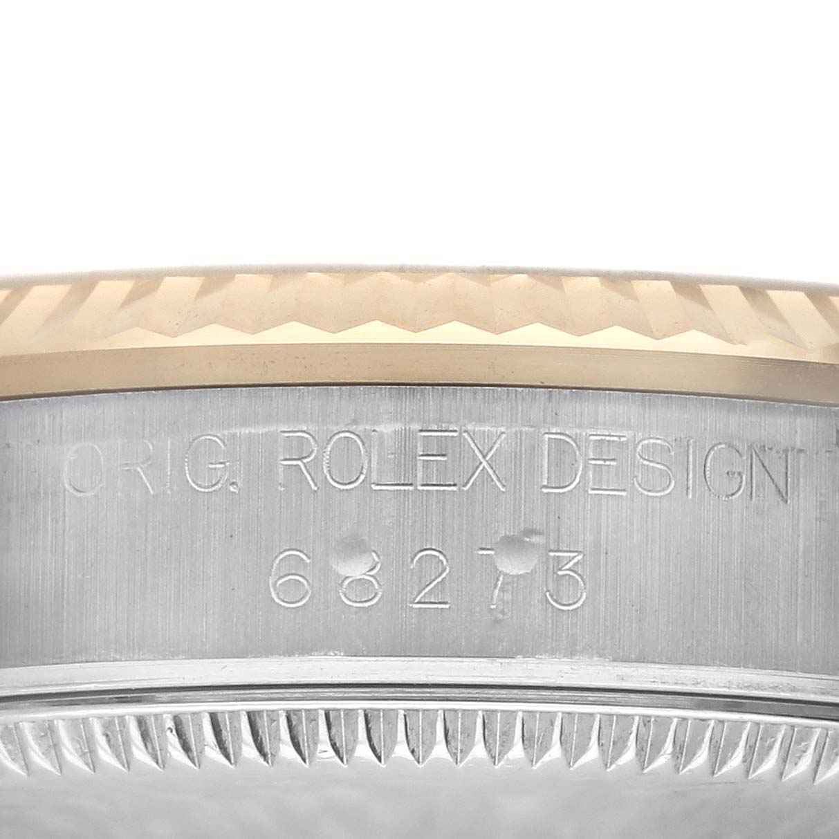 The image shows the side view of the bezel and case of a Rolex Mid-Size 68273 Women's Steel and Gold (two tone) Champagne Dial 68273 Women's Steel and Gold (two tone) Champagne Dial watch, featuring engraved text and watch model numbers.