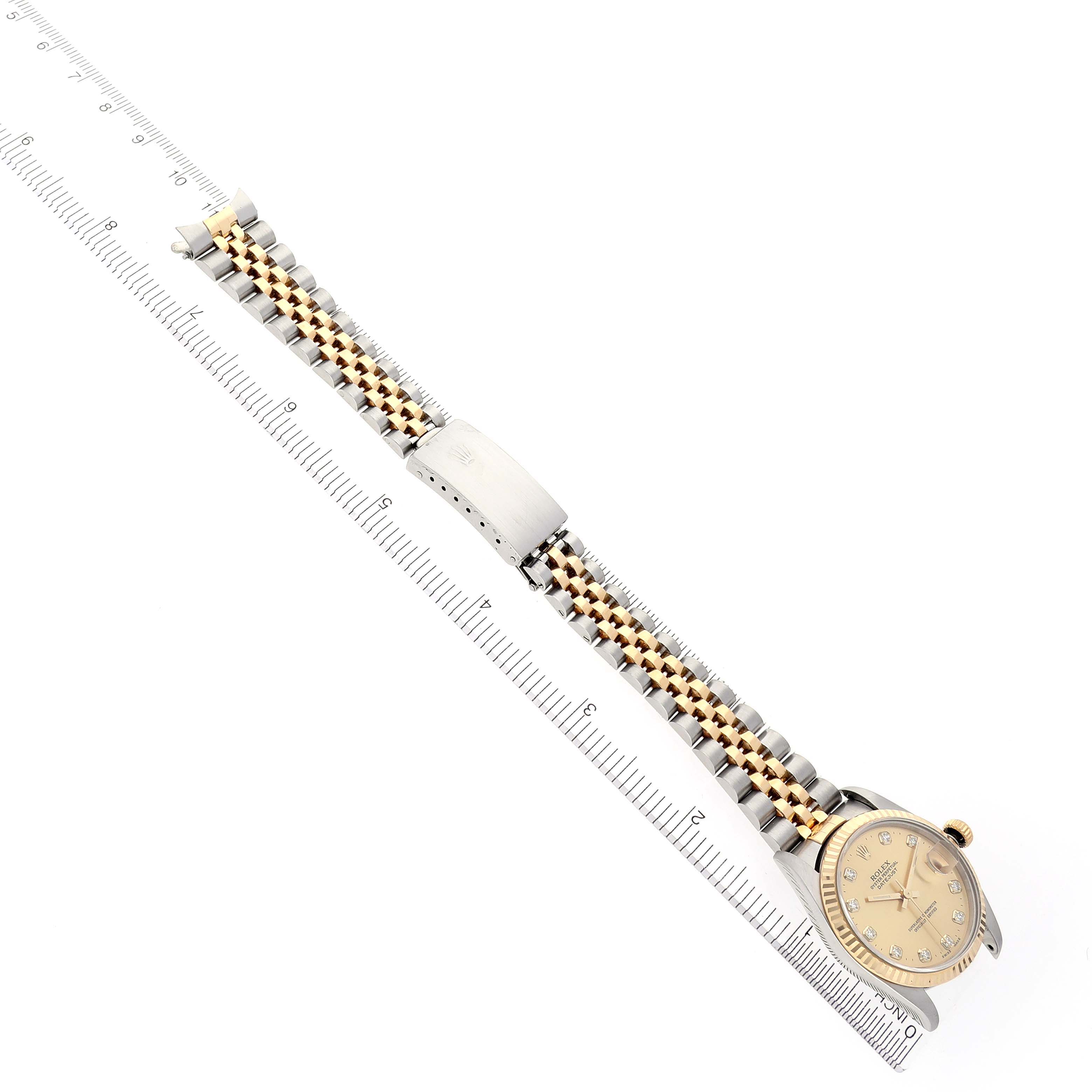 The Rolex Mid-Size 68273 Women's Steel and Gold (two tone) Champagne Dial 68273 Women's Steel and Gold (two tone) Champagne Dial watch is shown from a top view, displaying its full bracelet and face alongside a ruler for scale.