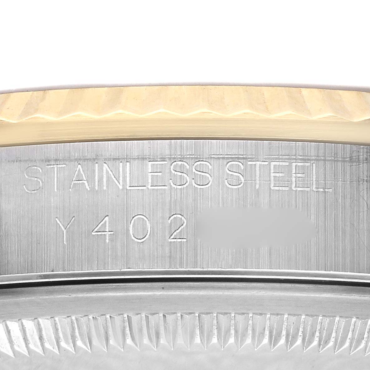 The image shows a close-up of the case side of a Rolex Datejust 16233 Men's Steel and Gold (two tone) Champagne Dial 16233 Men's Steel and Gold (two tone) Champagne Dial, focusing on the engraved serial number and metal type.