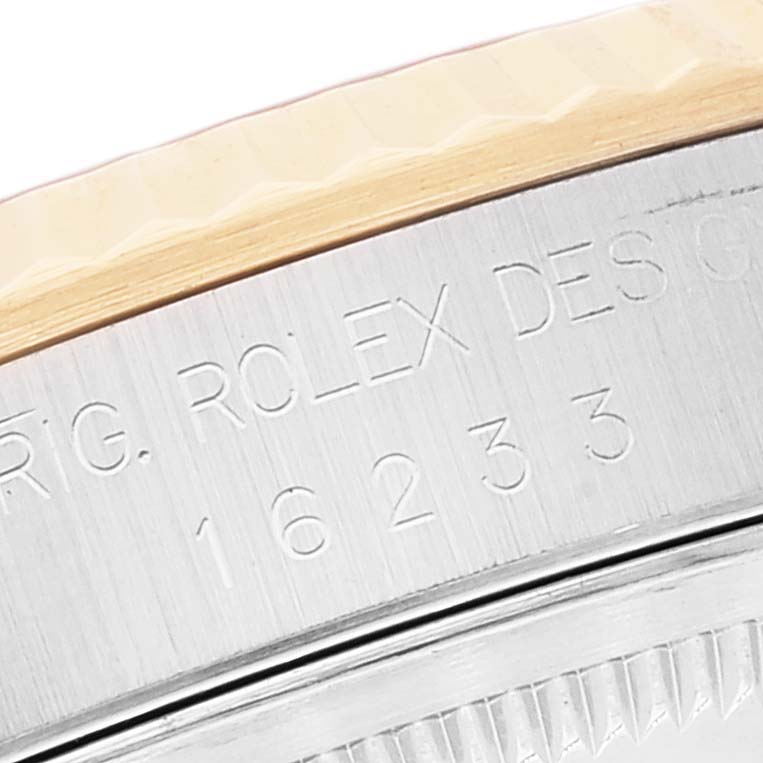 The image shows the edge of the bezel and the serial number engraved on the case of a Rolex Datejust 16233 Men's Steel and Gold (two tone) Beige Dial 16233 Men's Steel and Gold (two tone) Beige Dial watch.