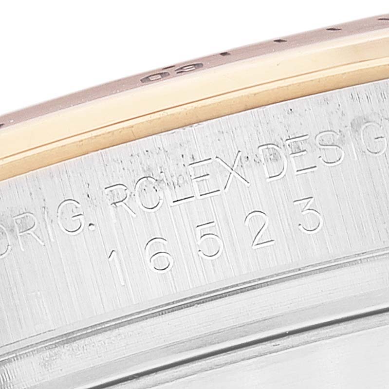 This close-up image shows the engraved serial number and part of the bezel of a Rolex Daytona 16523 Men's Steel and Gold (two tone) White Dial 16523 Men's Steel and Gold (two tone) White Dial watch.