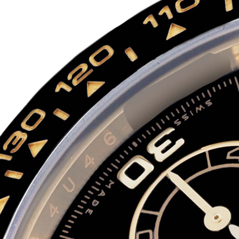 The image shows a close-up of the bezel and part of the dial of a Rolex Daytona 116518LNG Men's Yellow Gold Black Dial 116518LNG Men's Yellow Gold Black Dial watch.
