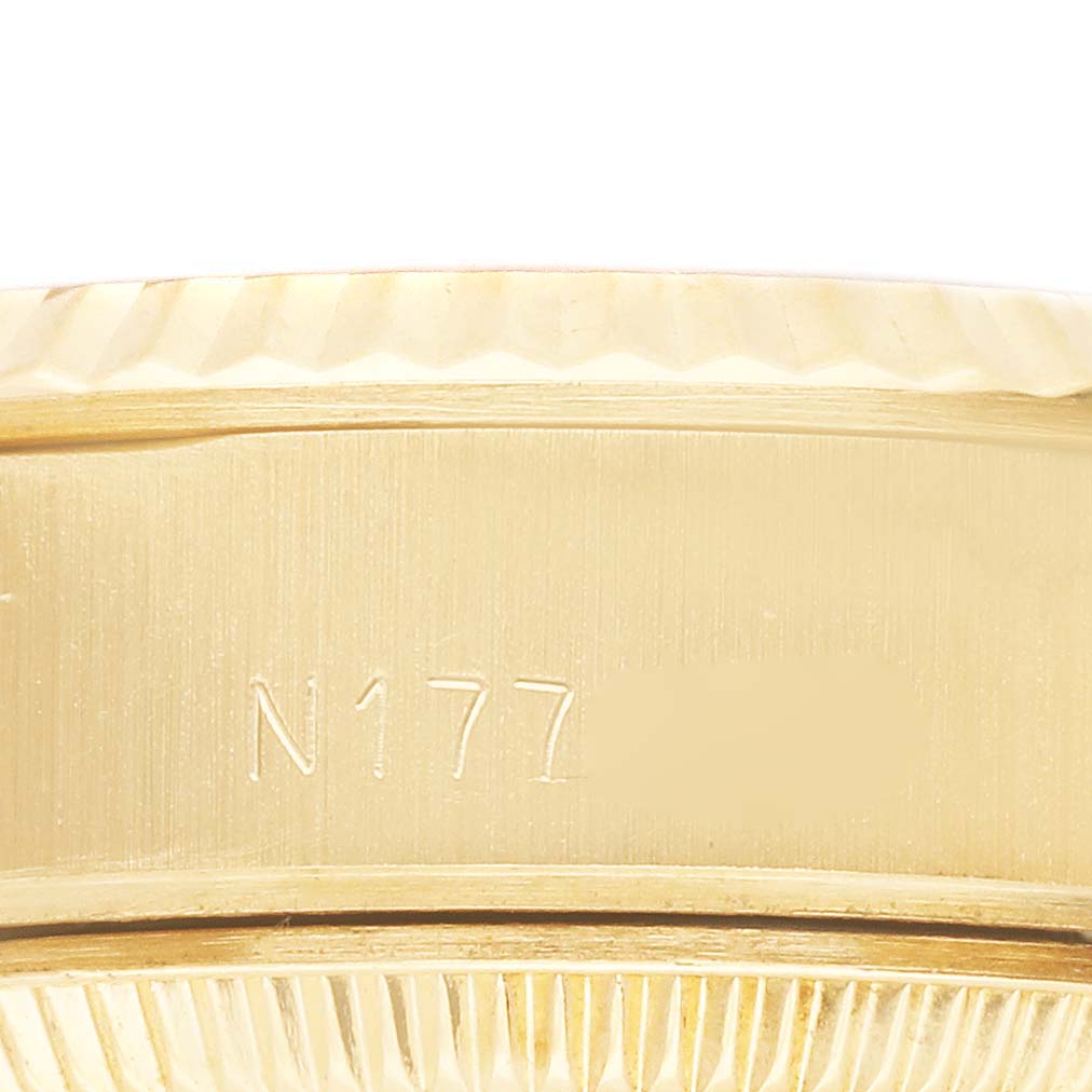 The image shows a close-up of the case side of a Rolex President 69178 Women's Yellow Gold Champagne Dial 69178 Women's Yellow Gold Champagne Dial model, featuring its fluted bezel and engraved serial number.