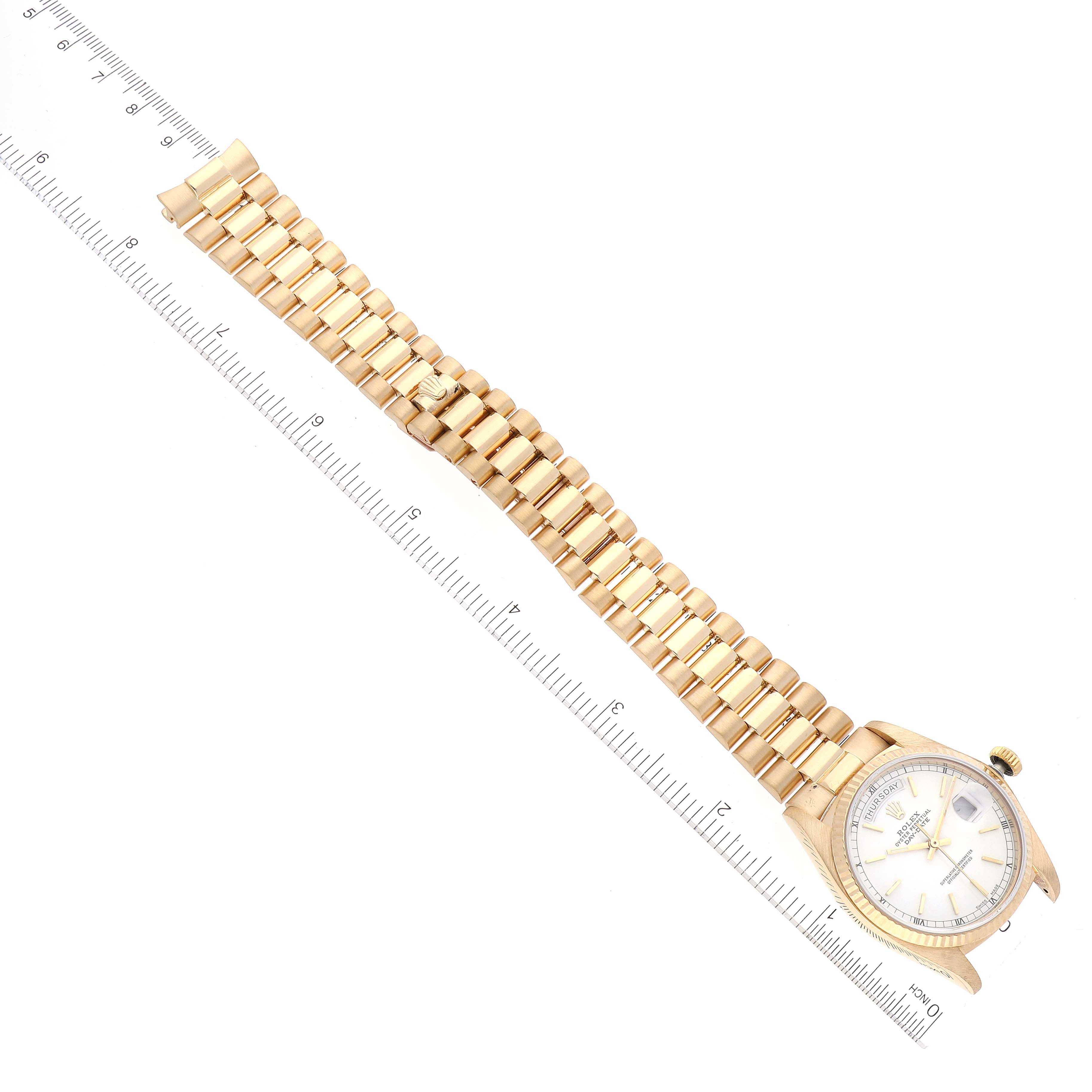 The image shows a Rolex President 18038 Men's Yellow Gold White Dial 18038 Men's Yellow Gold White Dial model watch laid flat, highlighting its bracelet and face next to a ruler for scale.