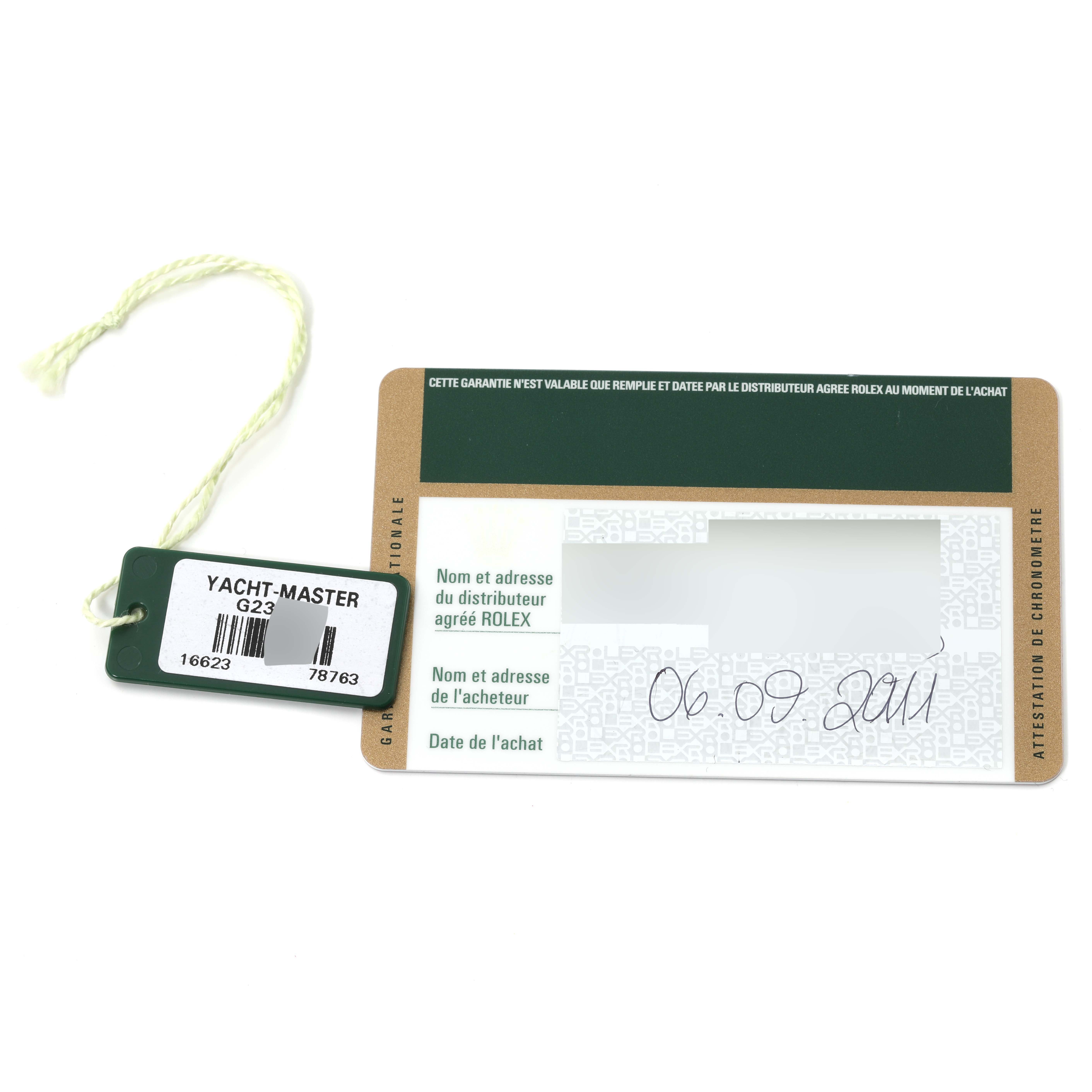 The image shows a warranty card and a tag for the Rolex Yacht-Master 16623 Men's Steel and Gold (two tone) Grey Dial 16623 Men's Steel and Gold (two tone) Grey Dial watch model.