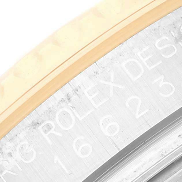 This close-up angle of a Rolex Yacht-Master 16623 Men's Steel and Gold (two tone) Grey Dial 16623 Men's Steel and Gold (two tone) Grey Dial watch displays part of the bezel and engraved text on the case.
