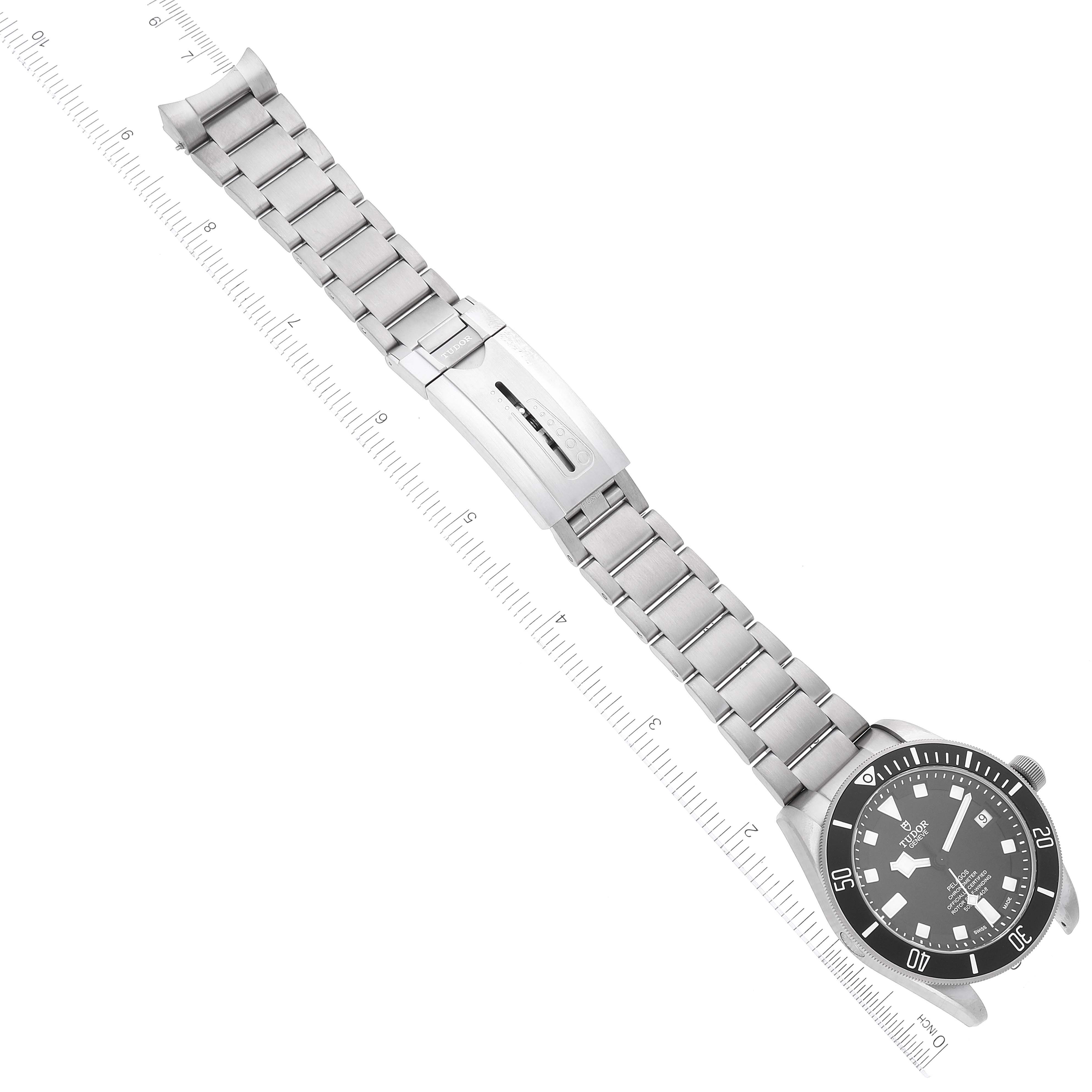 The image shows a full view of a Tudor Pelagos 25600TN Men
s Titanium Black Dial 25600TN Men
s Titanium Black Dial model watch with its stainless steel bracelet and clasp, displayed against a ruled measurement guide.
