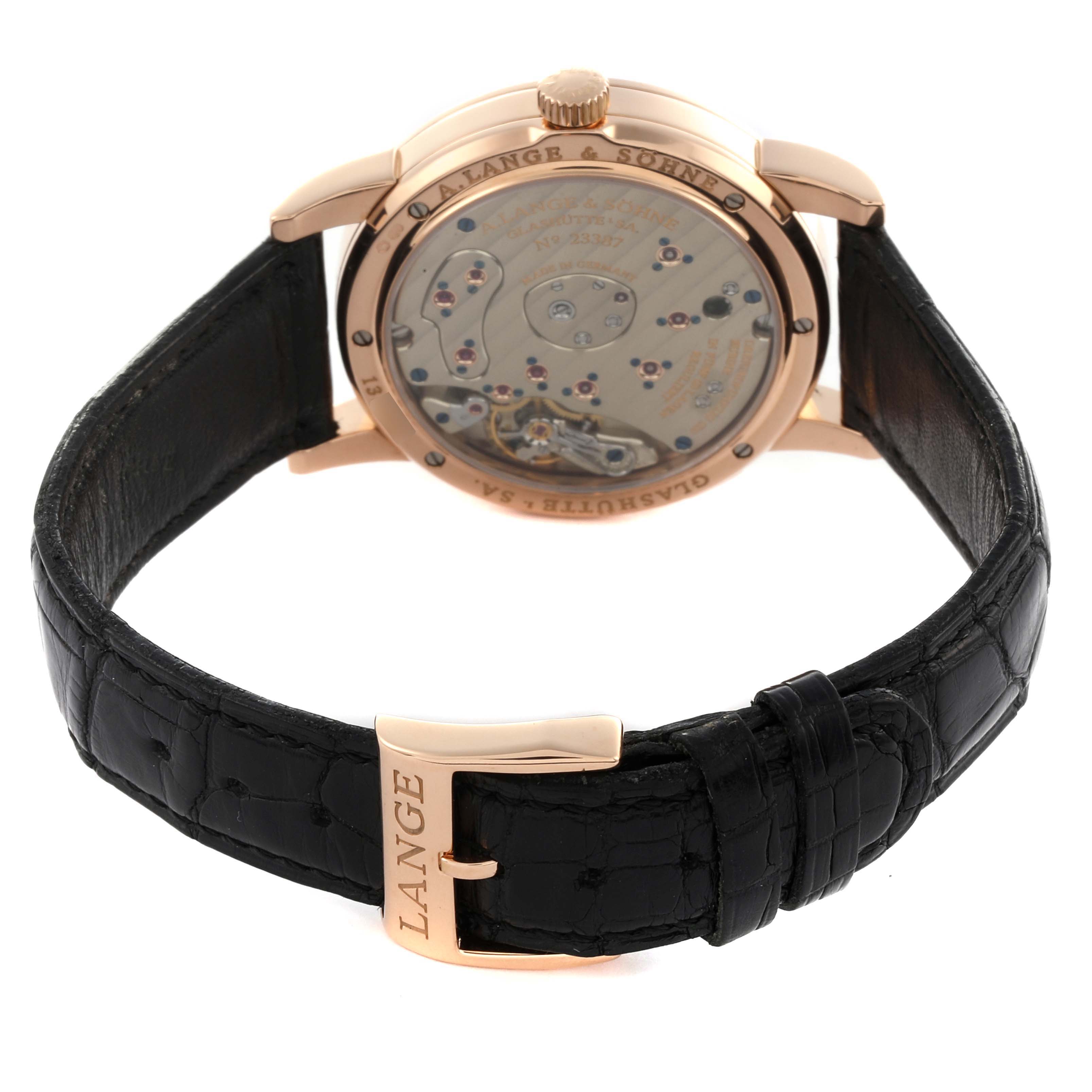 The A. Lange 
Sohne Lange 1 101.031 Men
s Rose Gold Black Dial watch is shown from the back, revealing its movement and featuring a black leather strap.