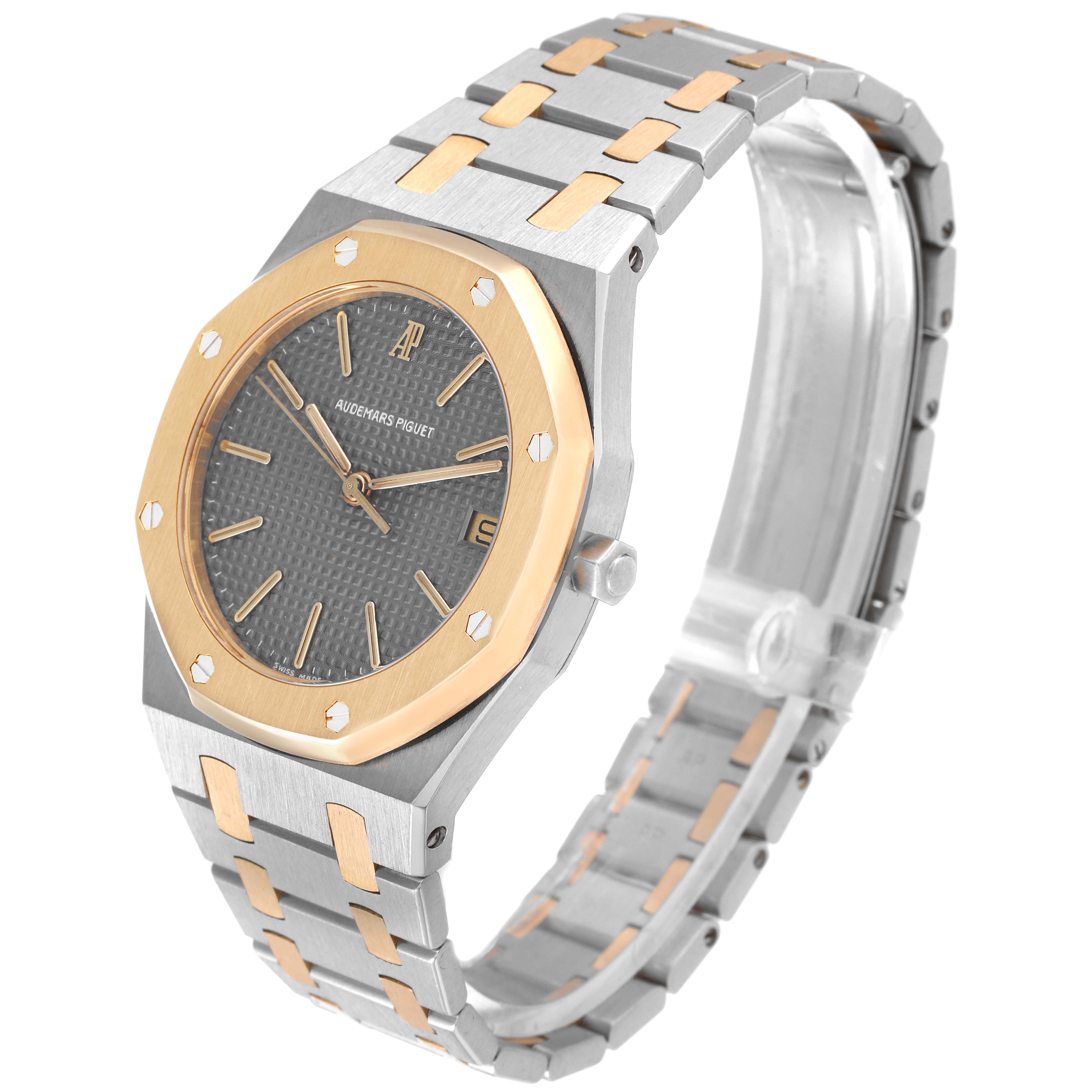 The image shows an Audemars Piguet Royal Oak 56023SA Men's Steel and Gold (two tone) Grey Dial 56023SA Men's Steel and Gold (two tone) Grey Dial watch, highlighting its octagonal bezel, bracelet, and dial at an angled side view.