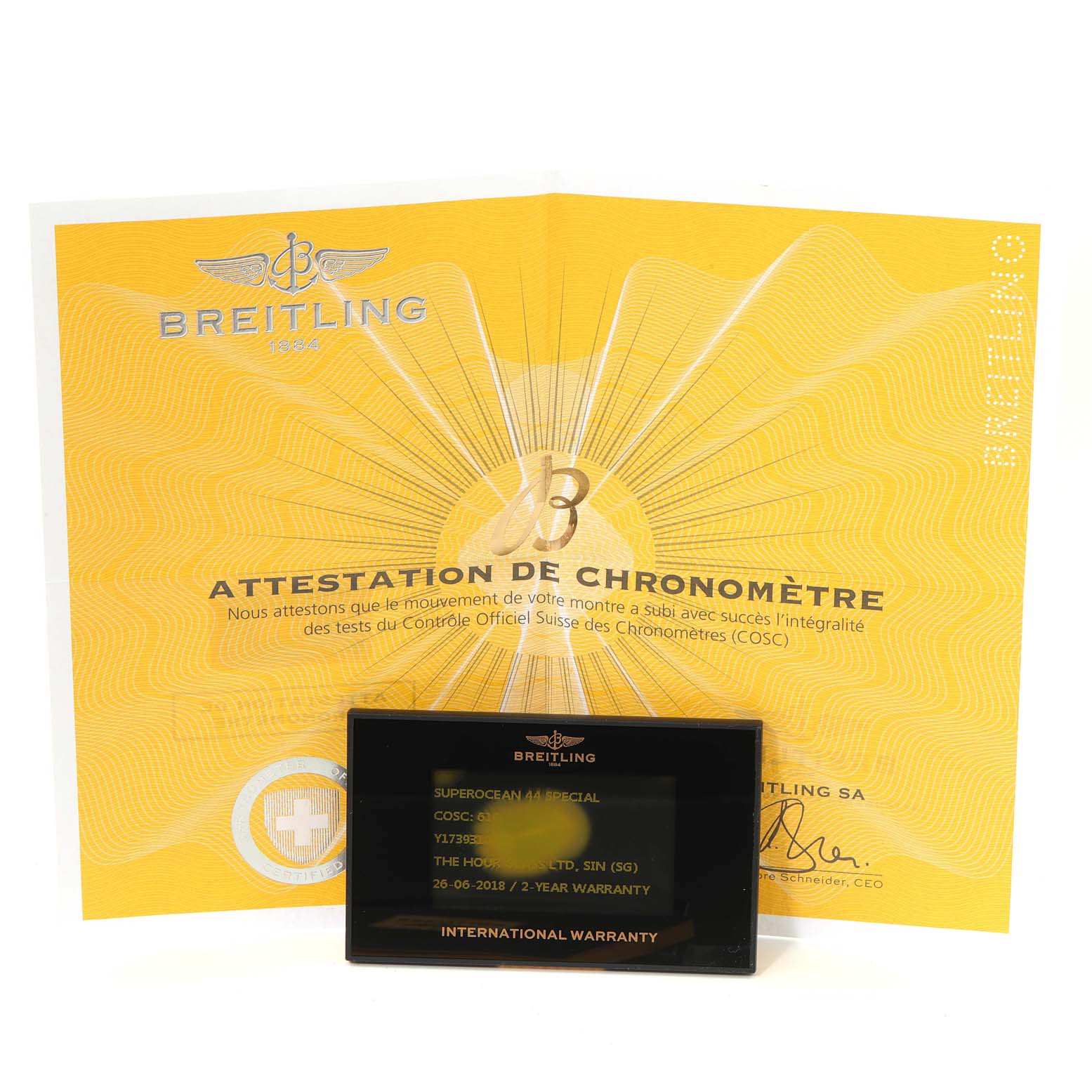 The image shows a Breitling Superocean Y17393 Men's Stainless Steel Black Dial Y17393 Men's Stainless Steel Black Dial model's yellow attestation of chronometer certificate and an international warranty card.