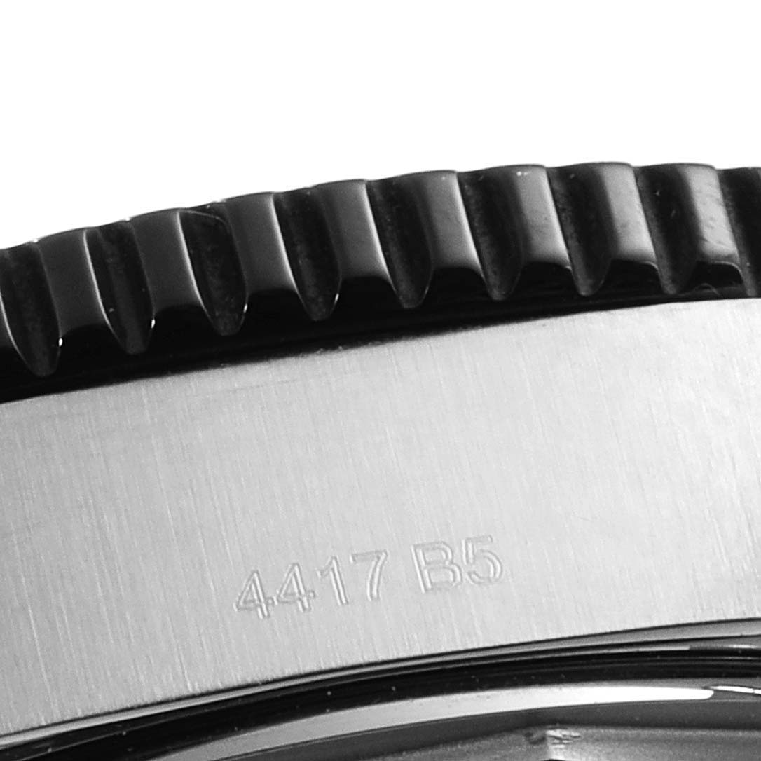 This close-up image of a Breitling Superocean Y17393 Men's Stainless Steel Black Dial Y17393 Men's Stainless Steel Black Dial watch shows the edge of the bezel and part of the case with an engraved serial number.