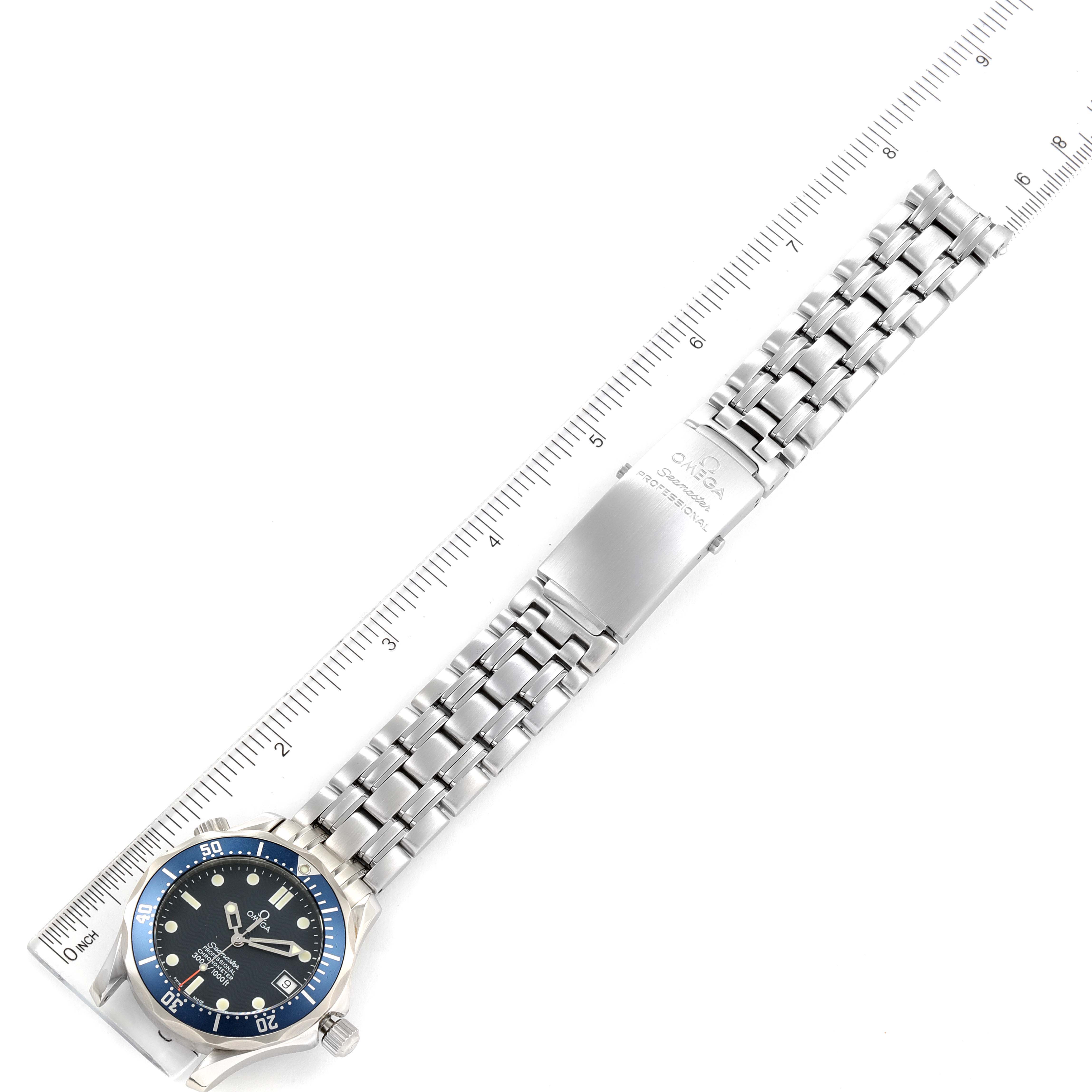 The image shows a top-down view of an Omega Seamaster 2551.80.00 Men's Stainless Steel Blue Dial 2551.80.00 Men's Stainless Steel Blue Dial watch including its dial, bracelet, and clasp, with a ruler beside it.