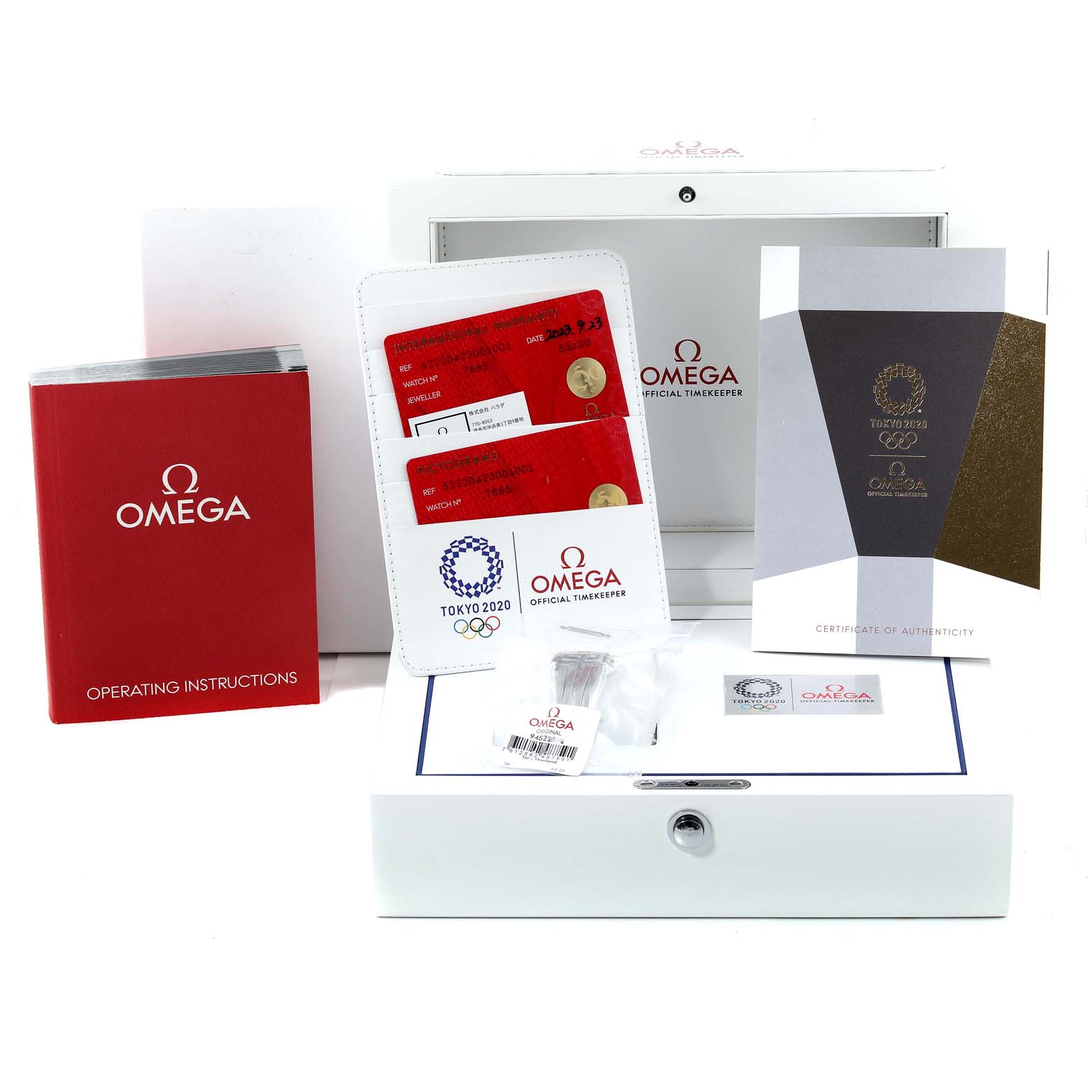 The image shows the packaging and accessories for an Omega Speedmaster 522.20.42.30.01.001 Men's Stainless Steel Black Dial 522.20.42.30.01.001 Men's Stainless Steel Black Dial, including documents, warranty cards, and an instruction manual.