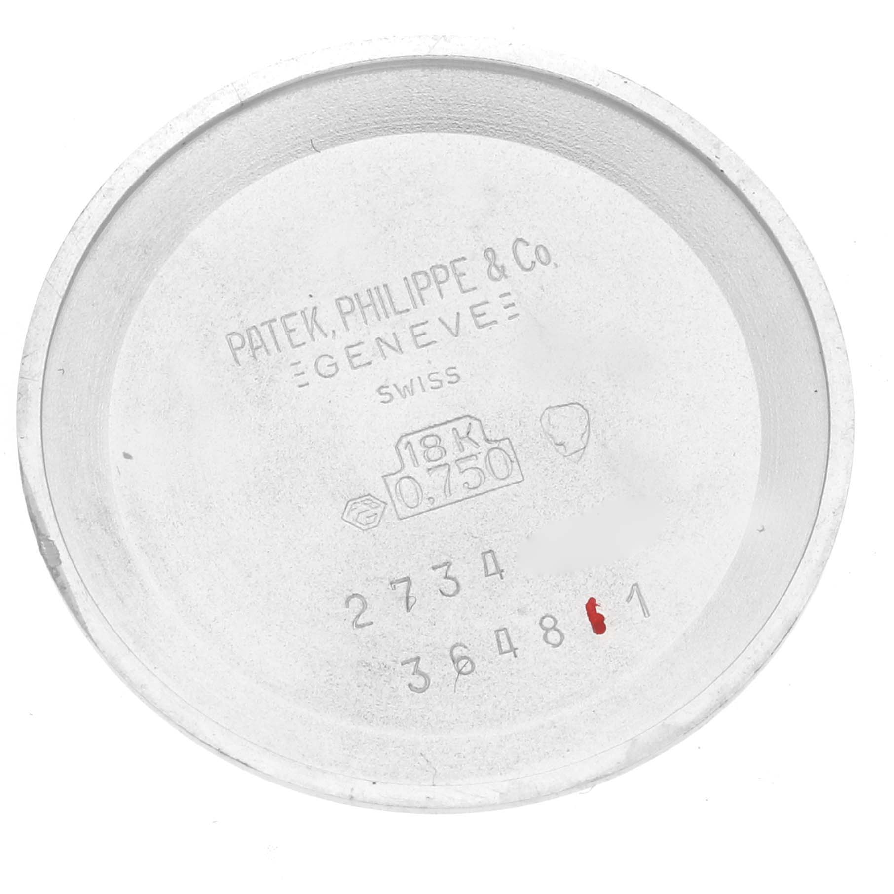 The image shows the inside of the case back of a vintage Patek Philippe watch, displaying engravings and stamps.