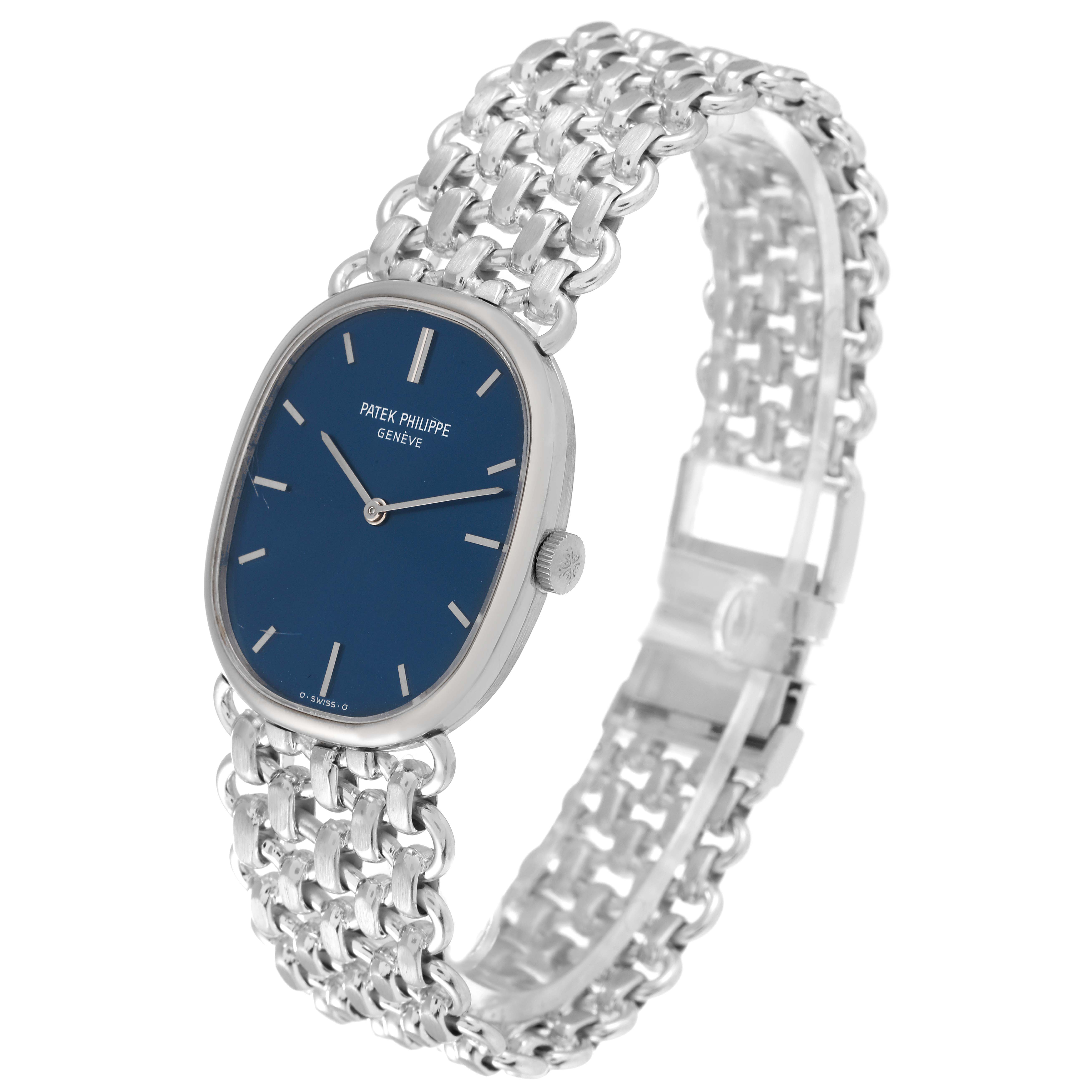 This image shows a Vintage Patek Philippe watch at a slight angle, highlighting its blue dial, oval case, and ornate metal bracelet.