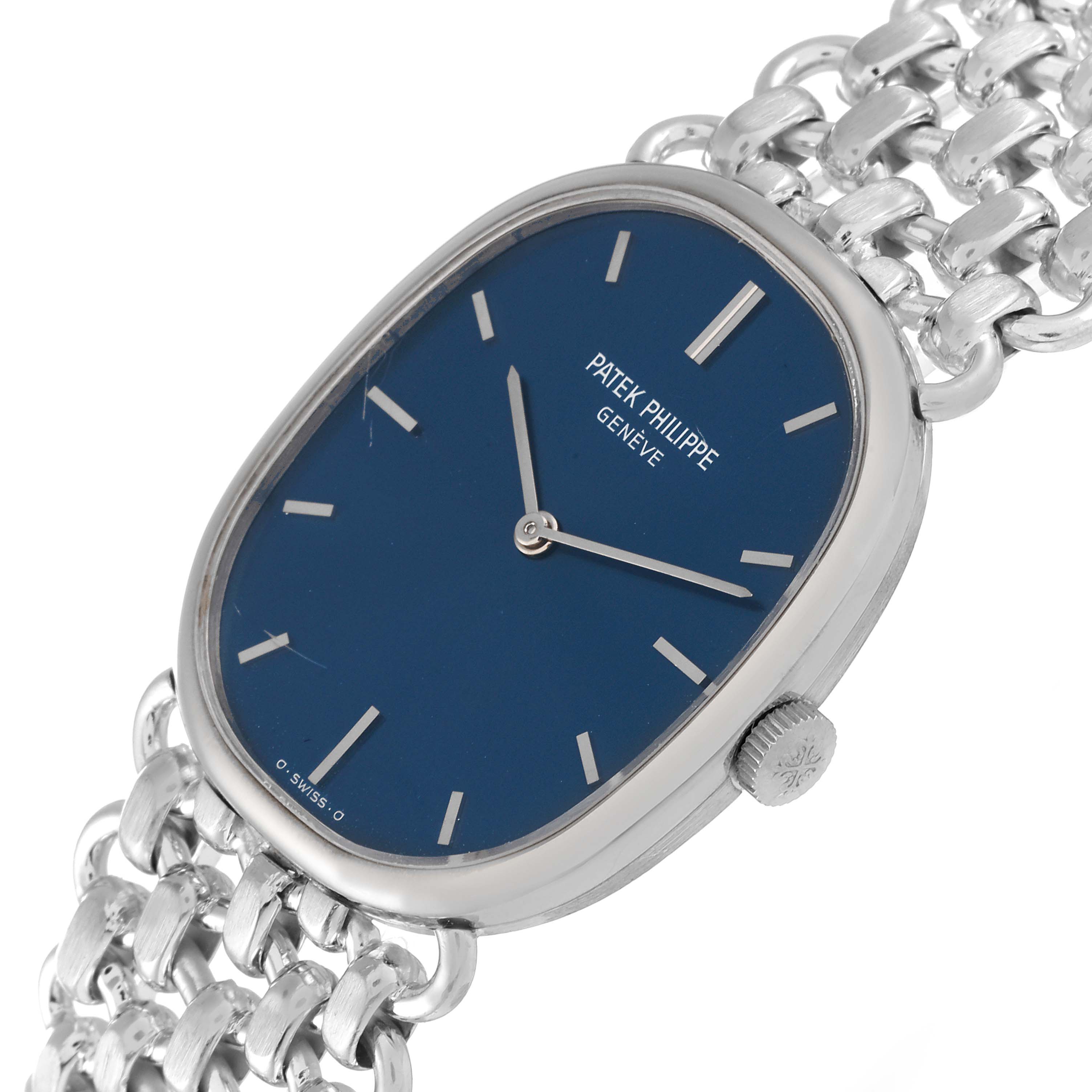The image shows a close-up, angled view of a Vintage Patek Philippe watch displaying its blue dial, silver hands, and metal bracelet.