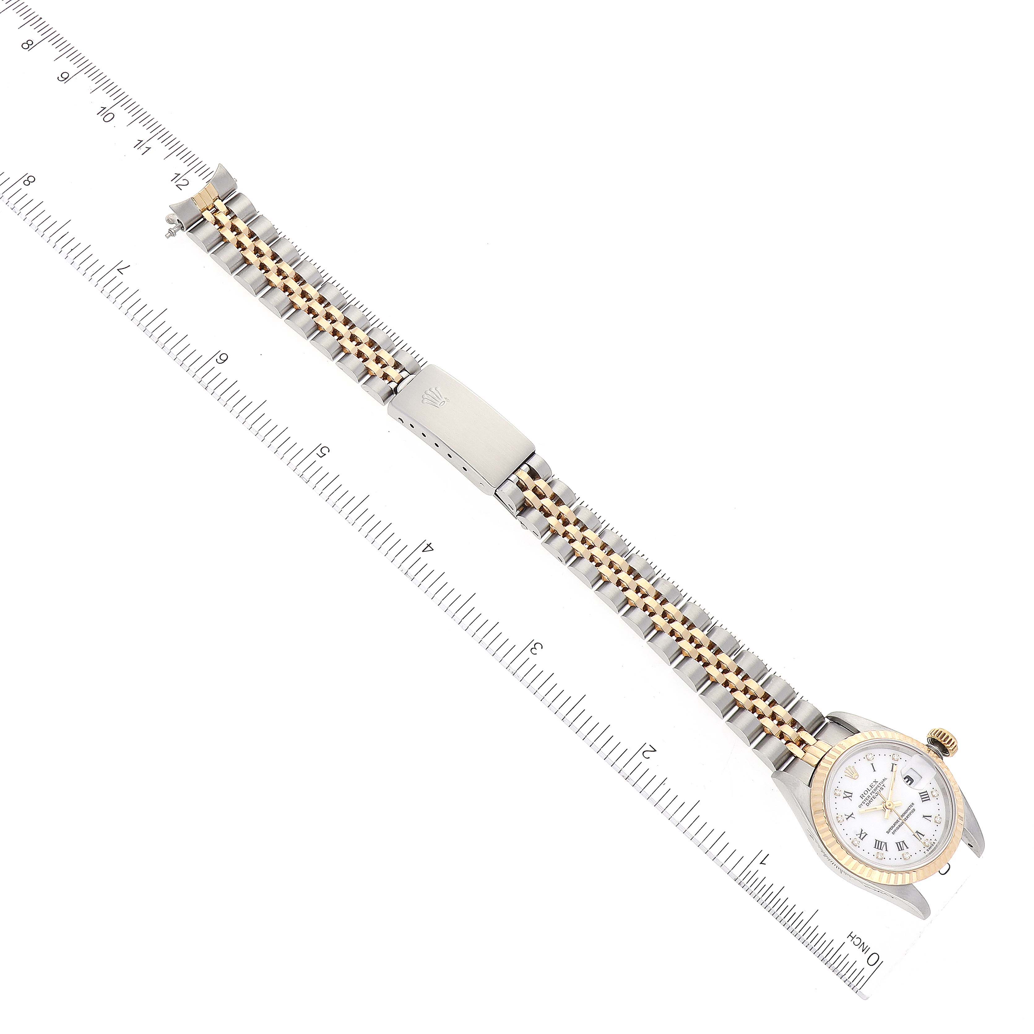 This image shows a Rolex Datejust 69173 Women's Steel and Gold (two tone) White Dial 69173 Women's Steel and Gold (two tone) White Dial watch laid flat with the band extended, and a ruler measuring it.