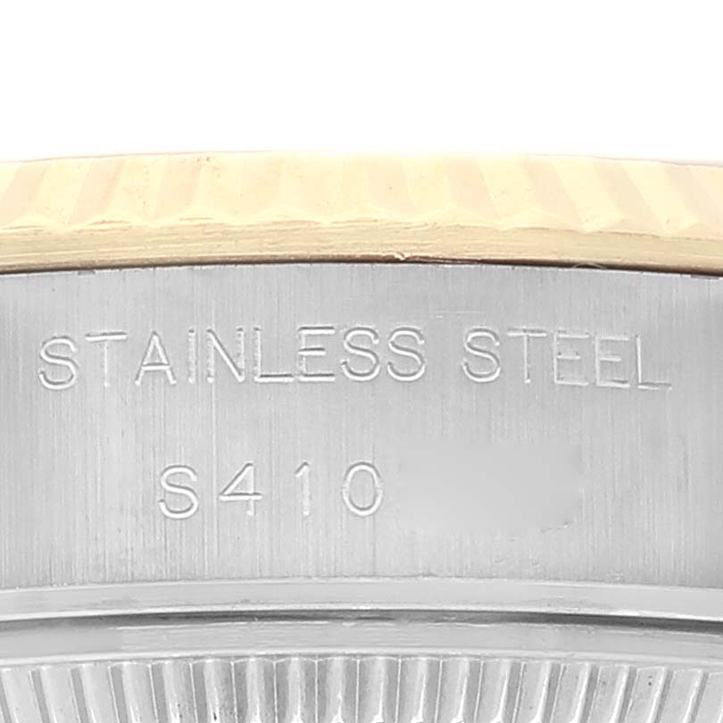The image shows a close-up of the side of the Rolex Datejust 69173 Women's Steel and Gold (two tone) White Dial 69173 Women's Steel and Gold (two tone) White Dial watch case, highlighting the stainless steel material and a serial number.