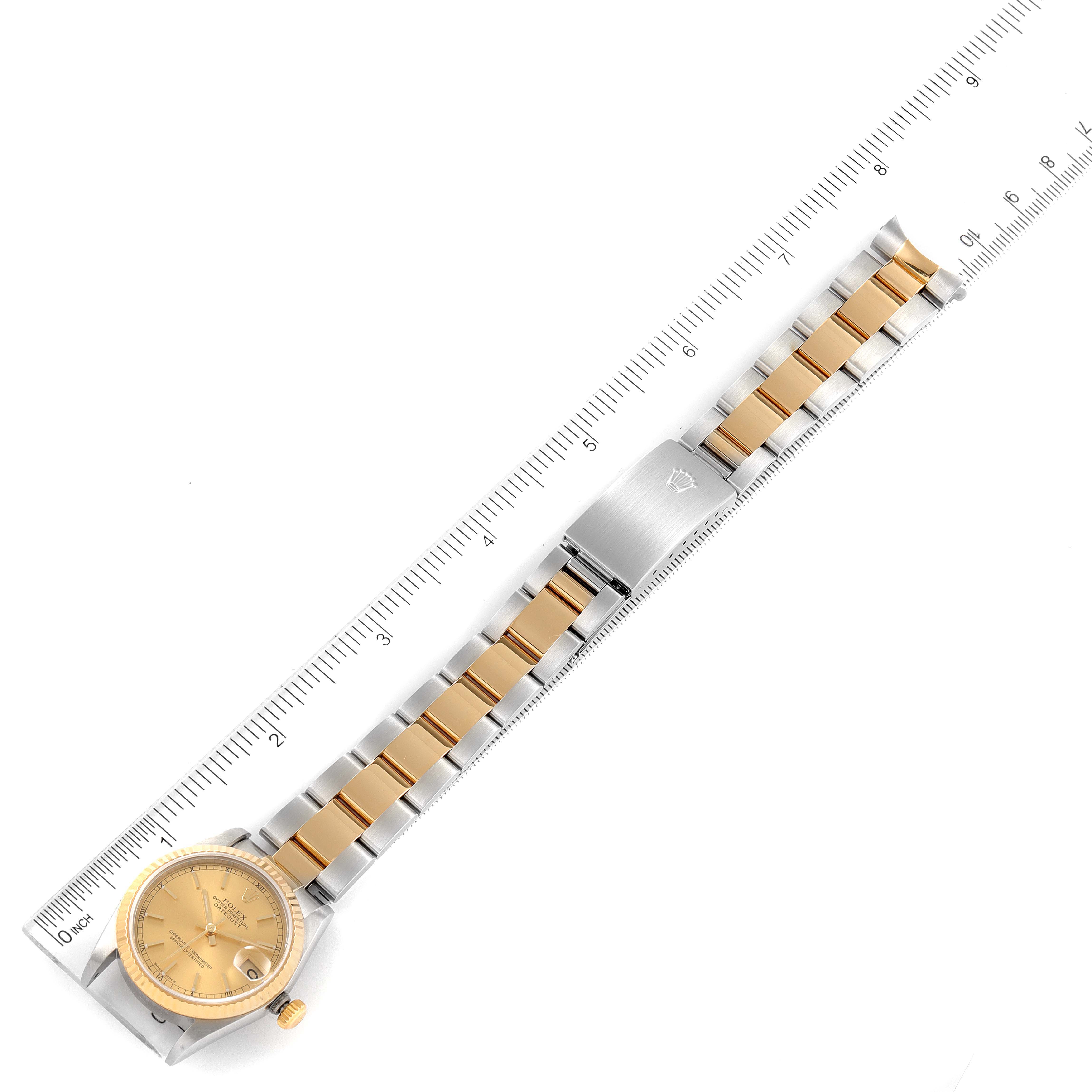 The Rolex Mid-Size 78273 Women's Steel and Gold (two tone) Champagne Dial 78273 Women's Steel and Gold (two tone) Champagne Dial model watch is shown fully extended with a ruler for scale, highlighting its face, band, and clasp.