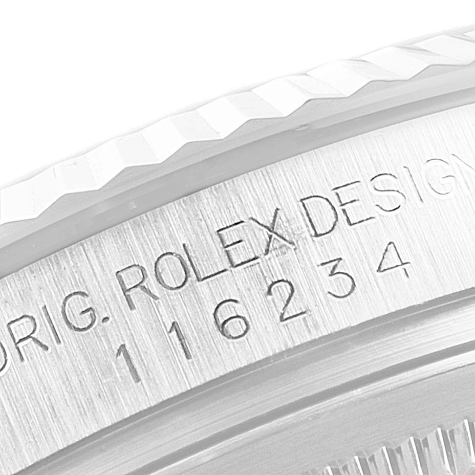 This is a close-up view of a Rolex Datejust 116234 Men's Stainless Steel Blue Dial 116234 Men's Stainless Steel Blue Dial watch, focusing on the engraved serial number and fluted bezel.