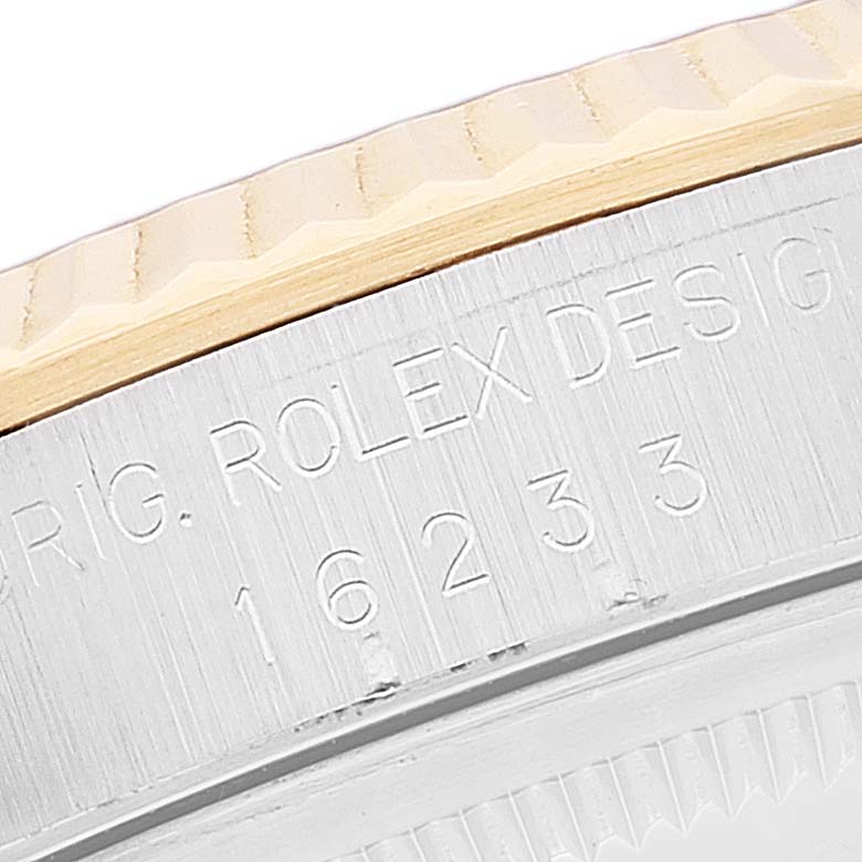 This image shows a close-up of the bezel and engraved case side of a Rolex Datejust 16233 Men's Steel and Gold (two tone) Blue Dial 16233 Men's Steel and Gold (two tone) Blue Dial watch.